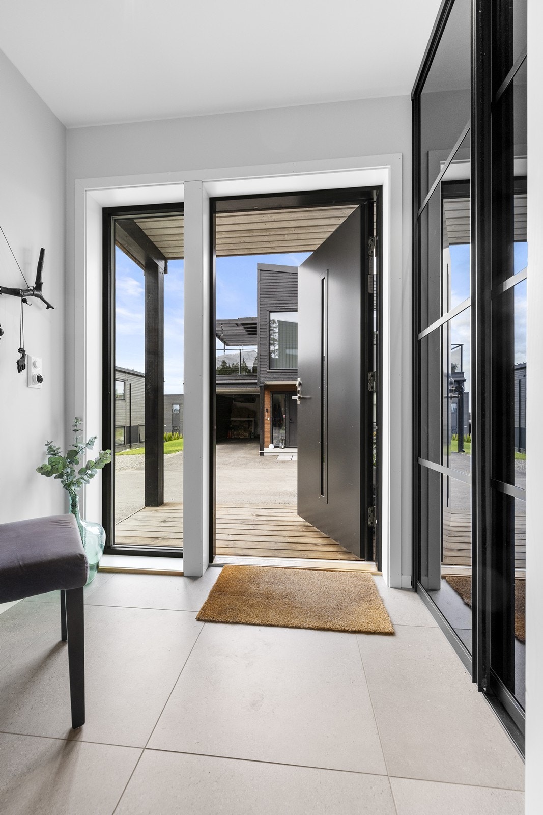 Entréen har fliser på gulvet med gulvvarme. Det er montert skyvedørsgarderobe. Galleribilde