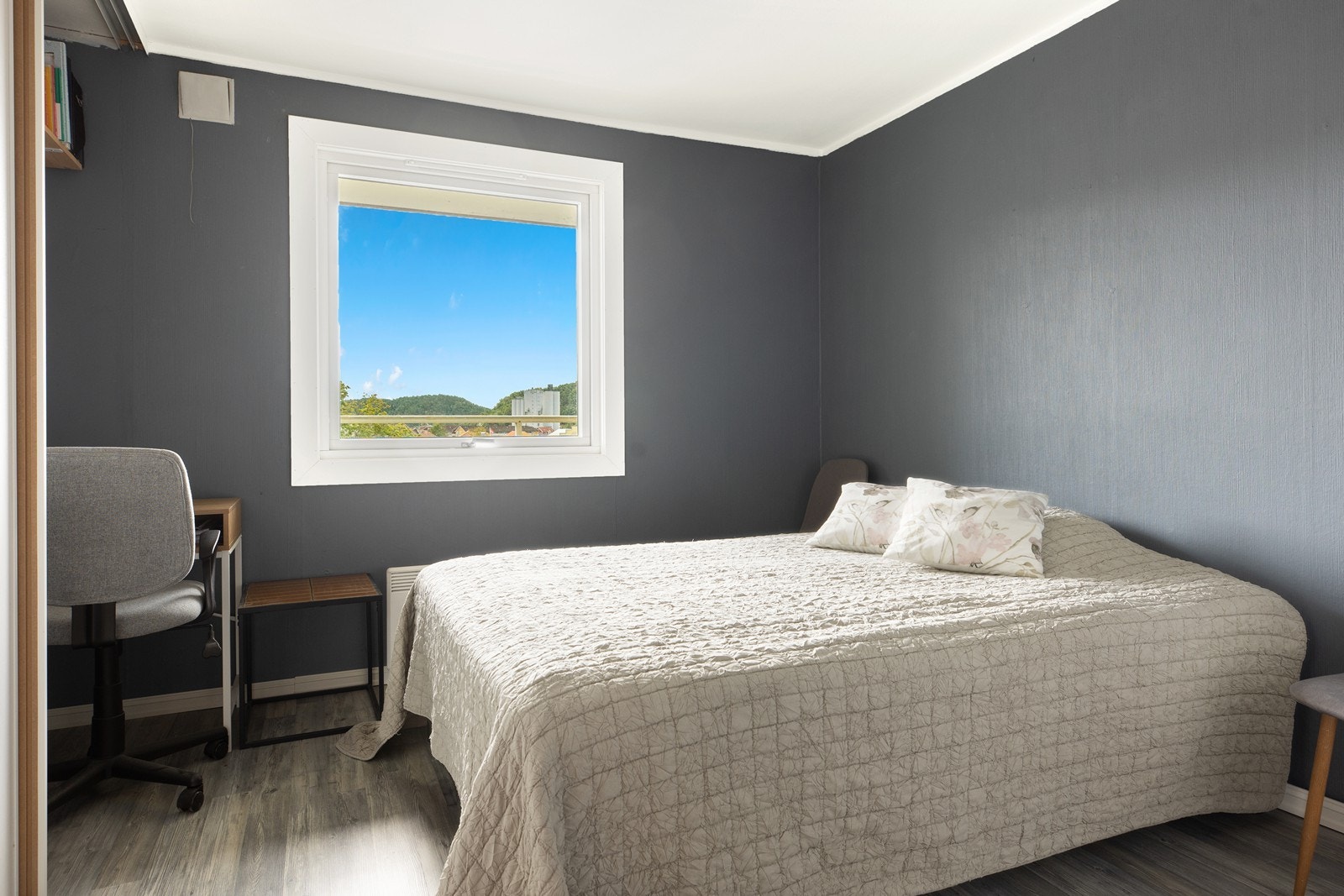 Soverommet er malt i en mørk og lun fargetone som skaper en behagelig og avslappende atmosfære. Rommet er romslig med god plass til dobbeltseng og nattbord, og har en praktisk skyvedørsgarderobe som gir rikelig med oppbevaringsplass for klær og tilbehør. Galleribilde