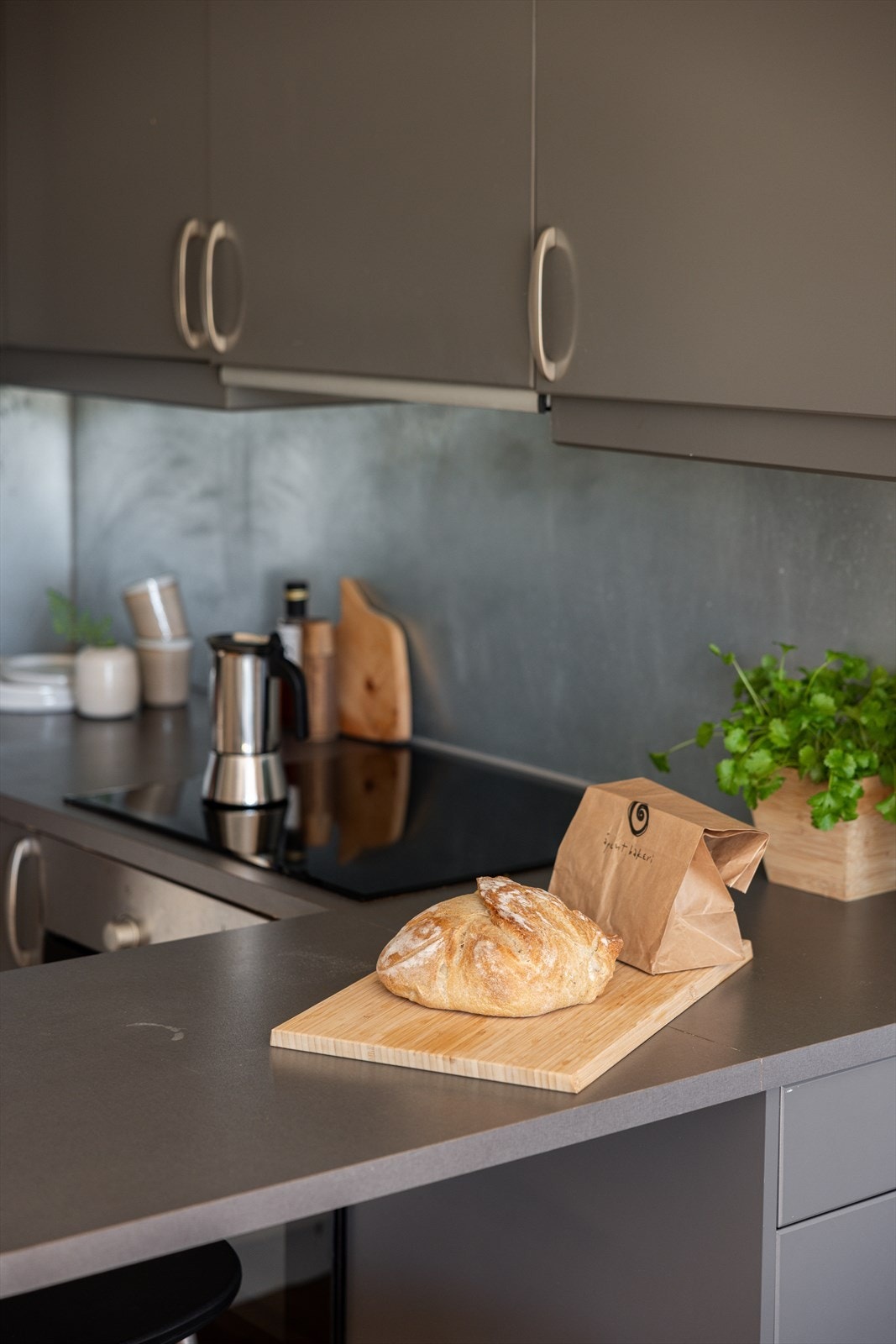 En mørk kjøkkeninnredning med glatte flater, benkeplate av laminat og med nedfelt oppvaskkum. Galleribilde