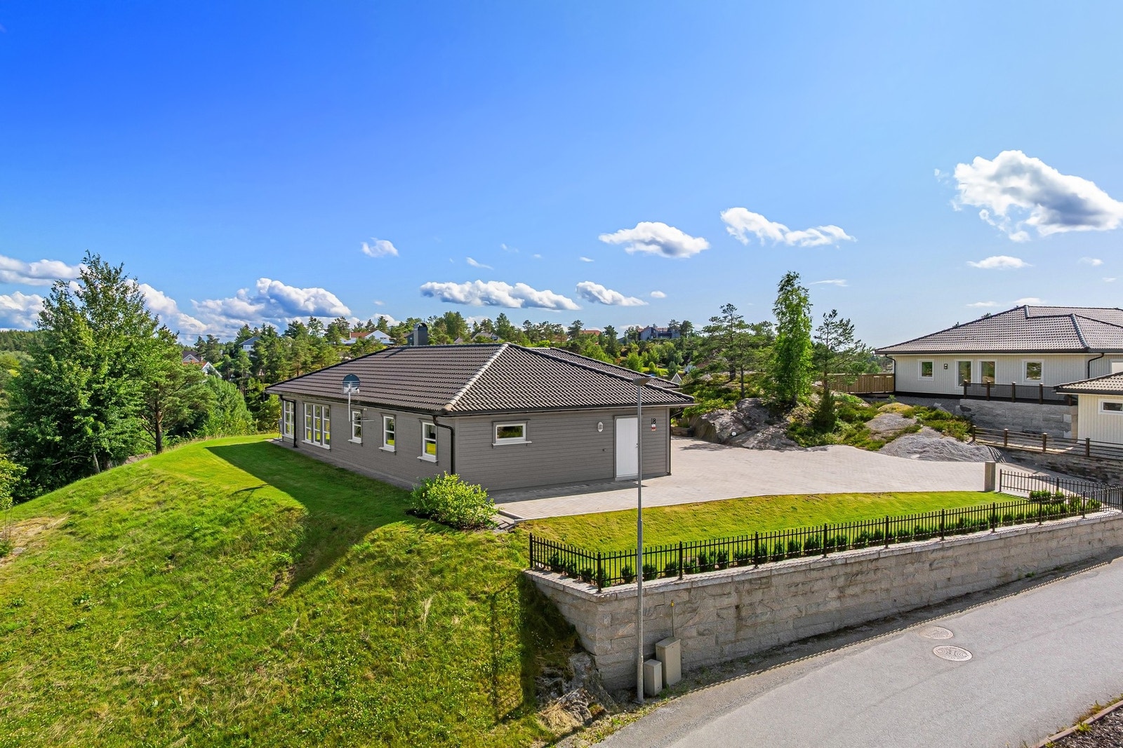 Hele eiendommen er svært påkostet med støttemur, smijernsgjerde og steinlagt gårdsplass. Galleribilde