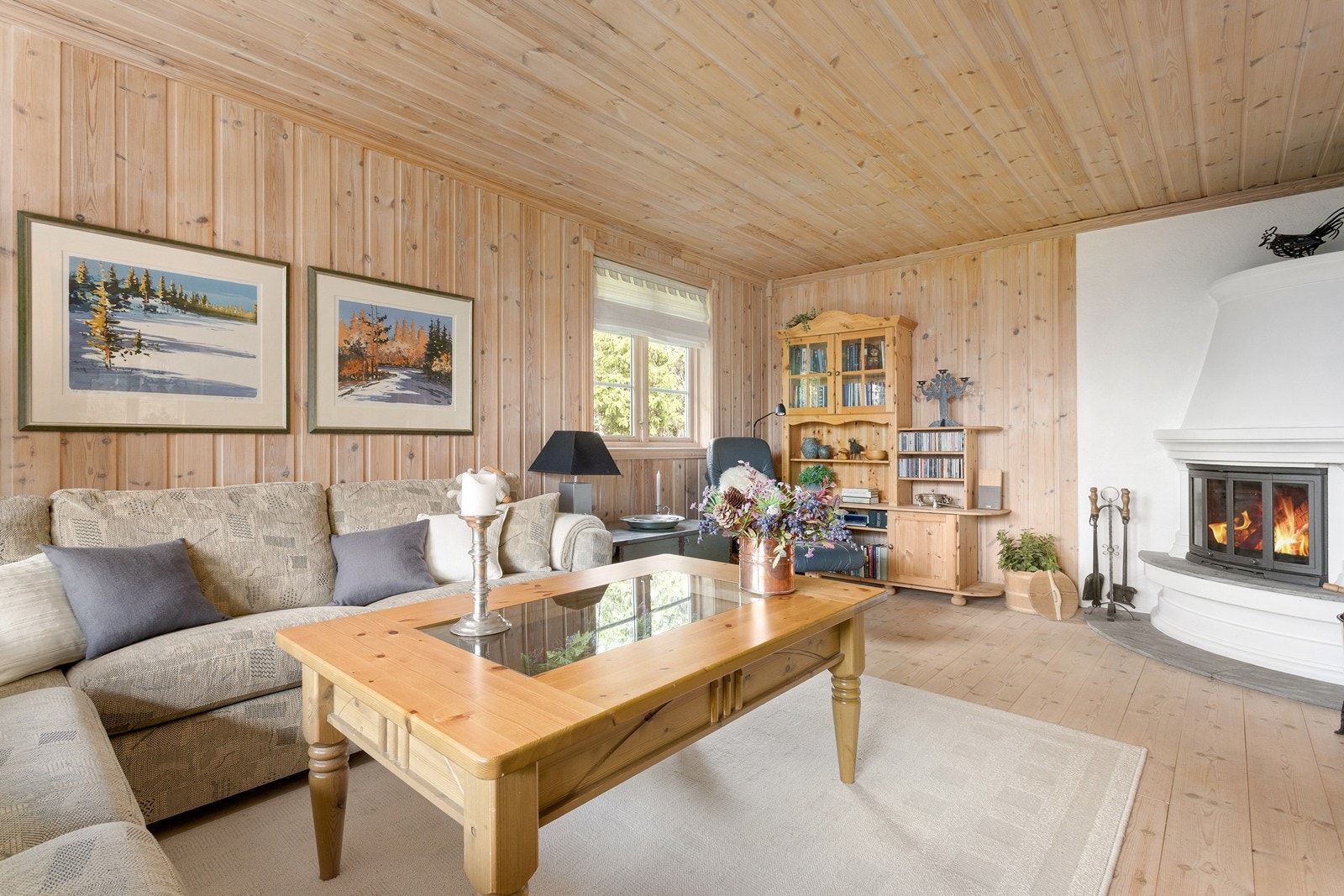 Hyggelig sofahjørne med peis og store vindusflater som slipper inne rikelig med naturlig belysning. Galleribilde