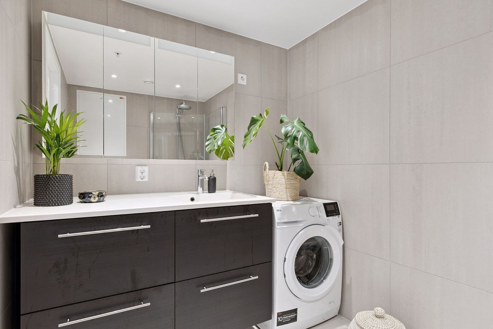 På badet er det gjort tilvalg på innredningen, noe som i tillegg til å sørge for oppbevaringsplass gir badet et estetisk løft fra nyboligformatet. Galleribilde