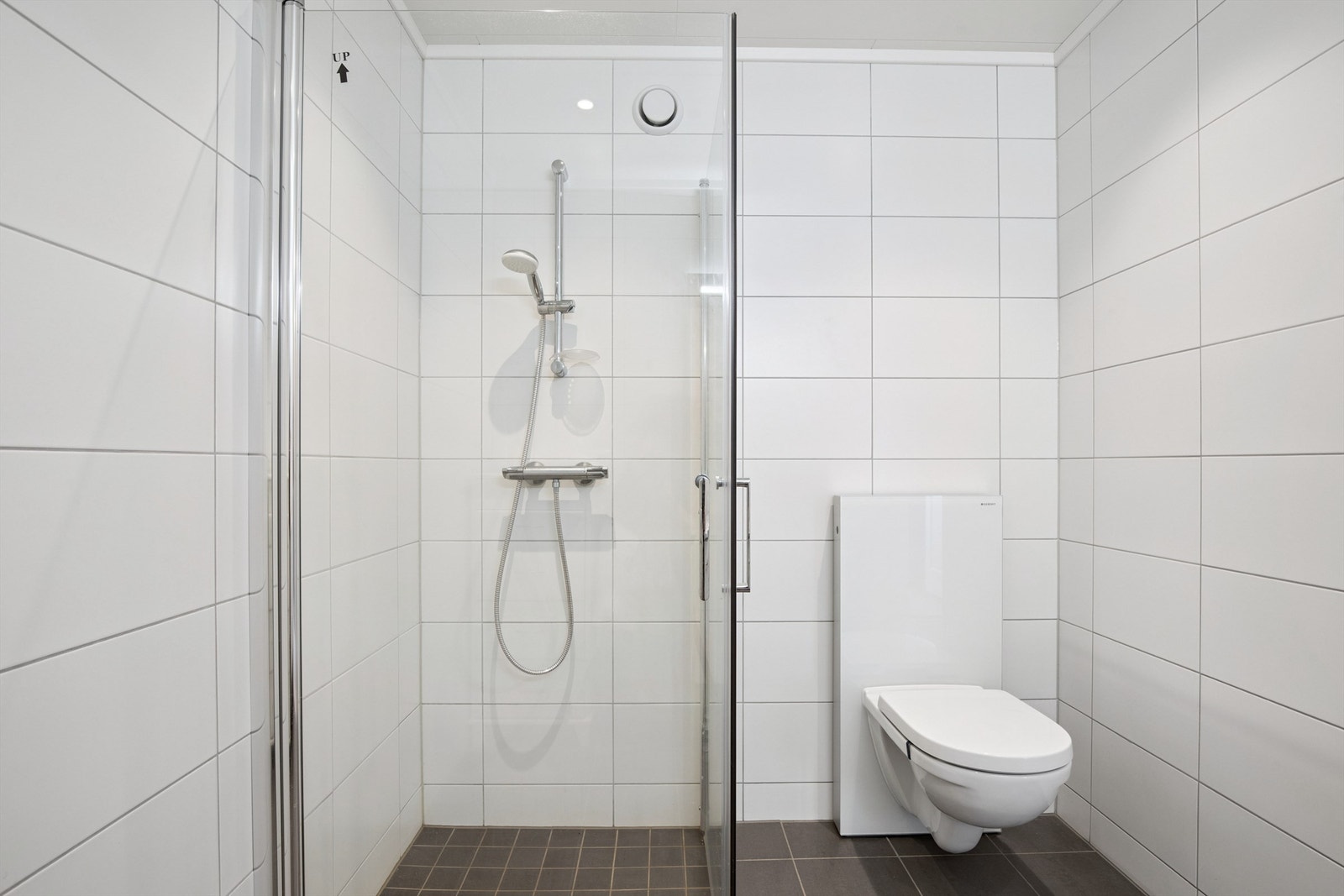 Delikat, flislagt bad med innfellbare dusjdører og vannbåren gulvvarme. Galleribilde