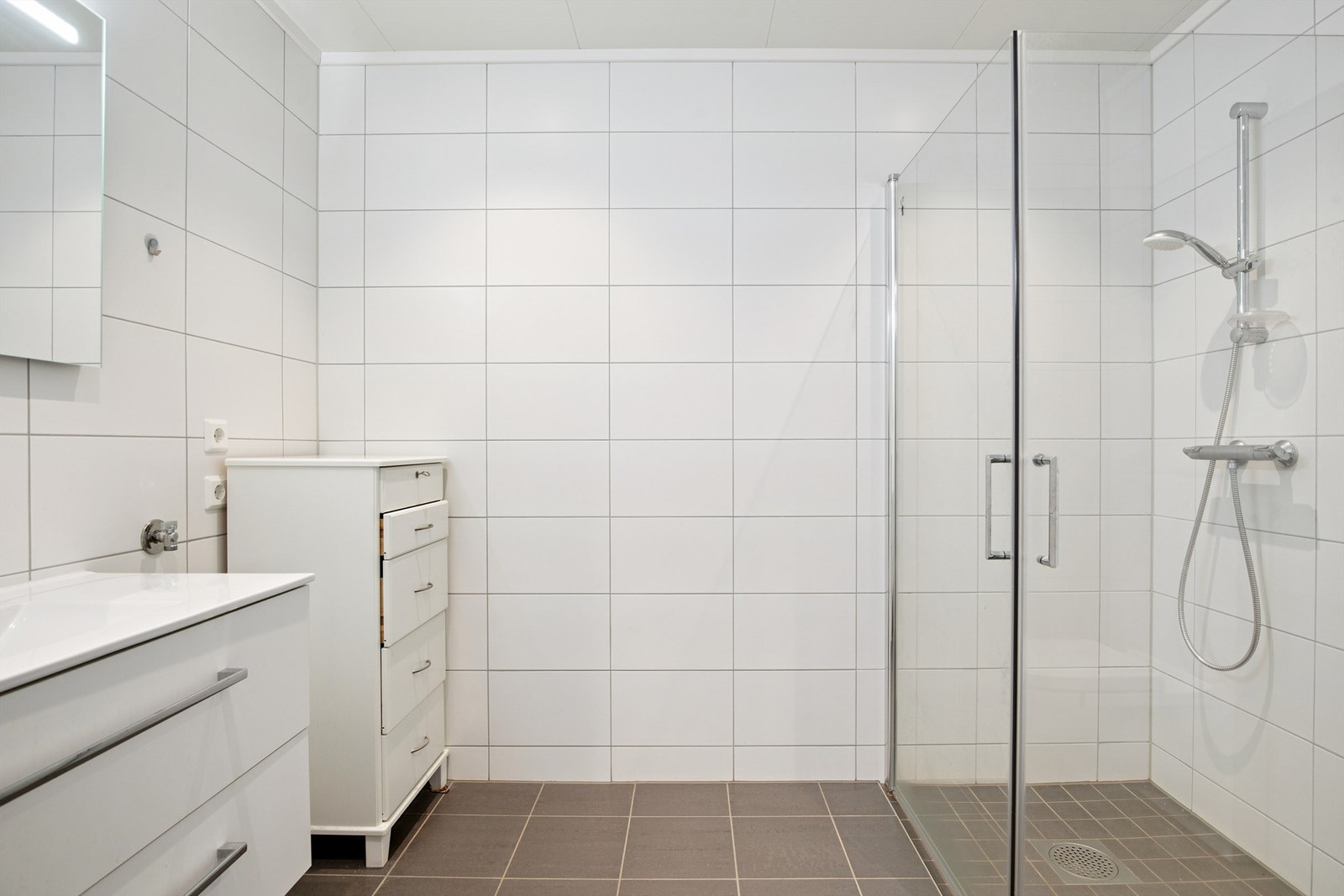 Stort og helfliset bad med opplegg for vaskemaskin. Galleribilde