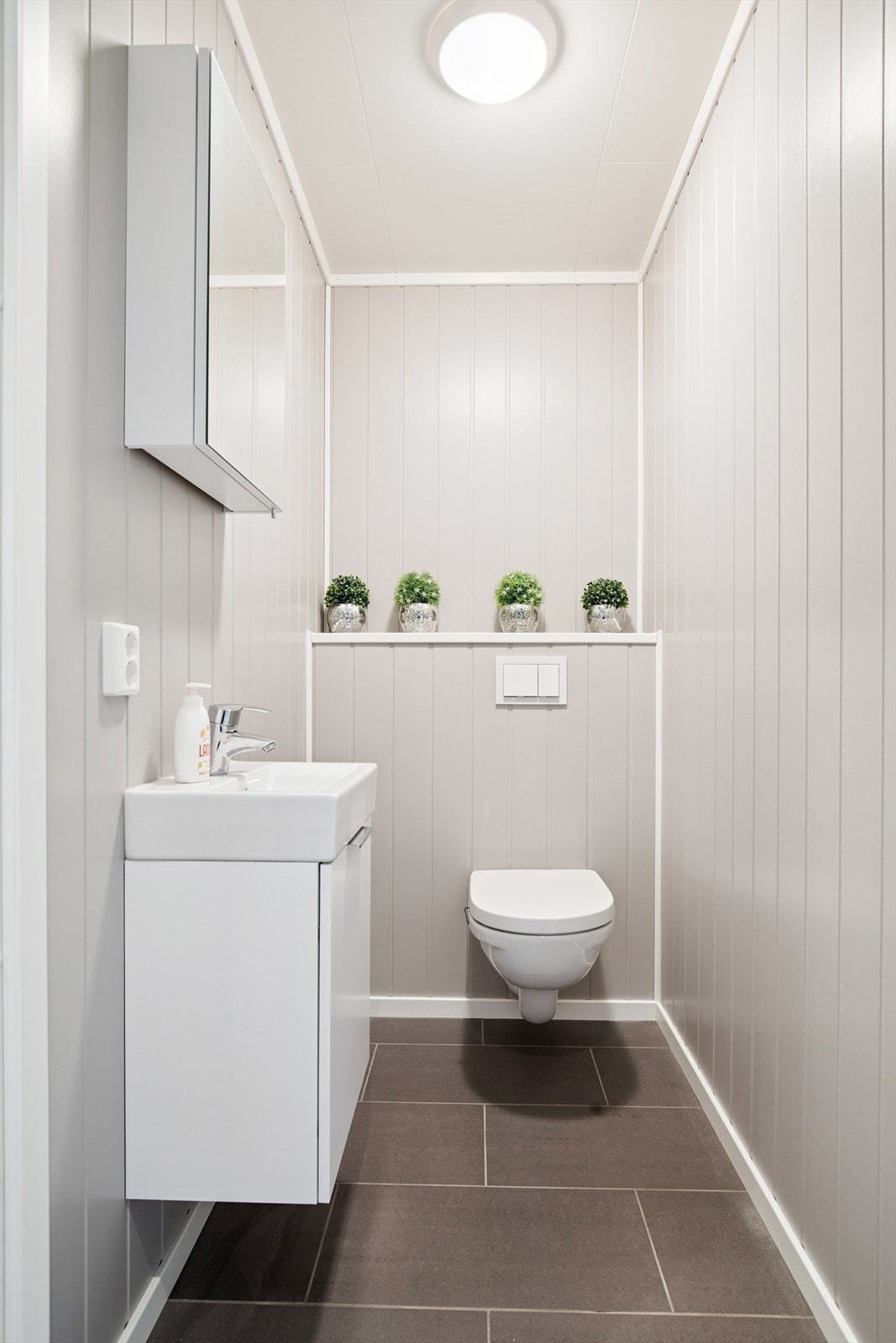 Praktisk toalettrom i første etasje med vegghengt toalett og servant. Galleribilde