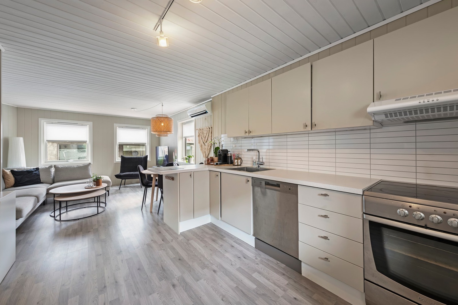 Lys kjøkkeninnredning med glatte fronter og benkeplate i laminat Galleribilde