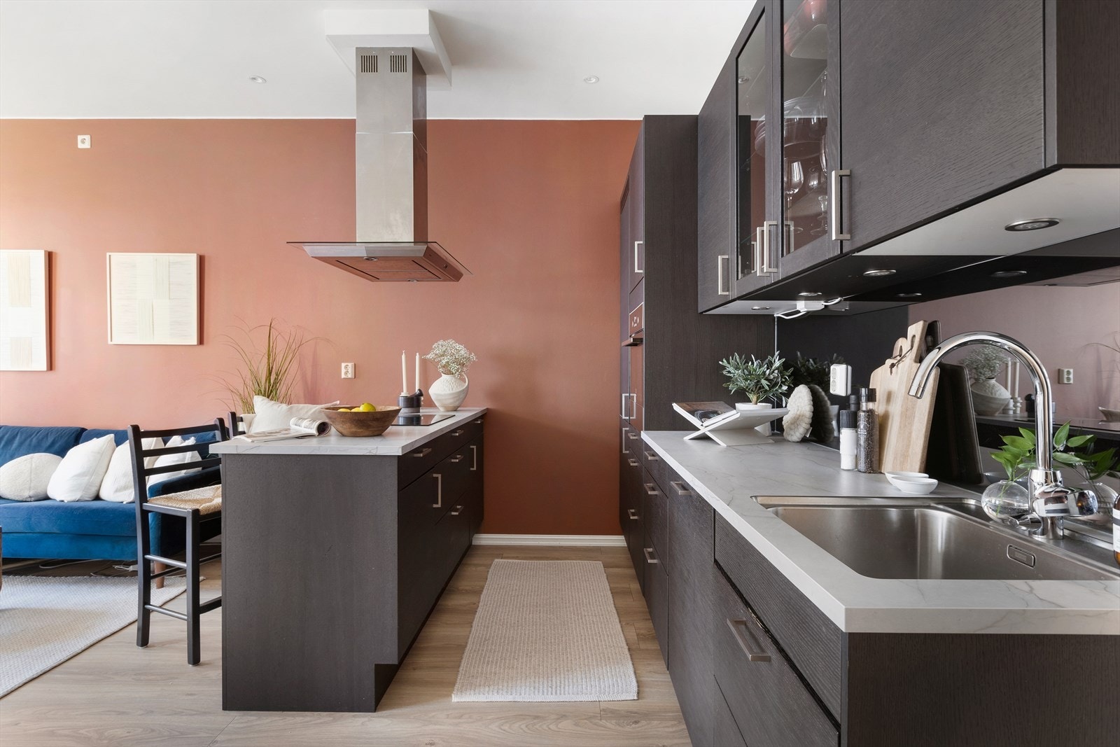 Den åpne løsningen med kjøkkenøy og stekeplate vendt mot stuen gjør matlagingen til en sosial opplevelse - perfekt for å inkludere gjester eller familien mens man lager mat. Galleribilde