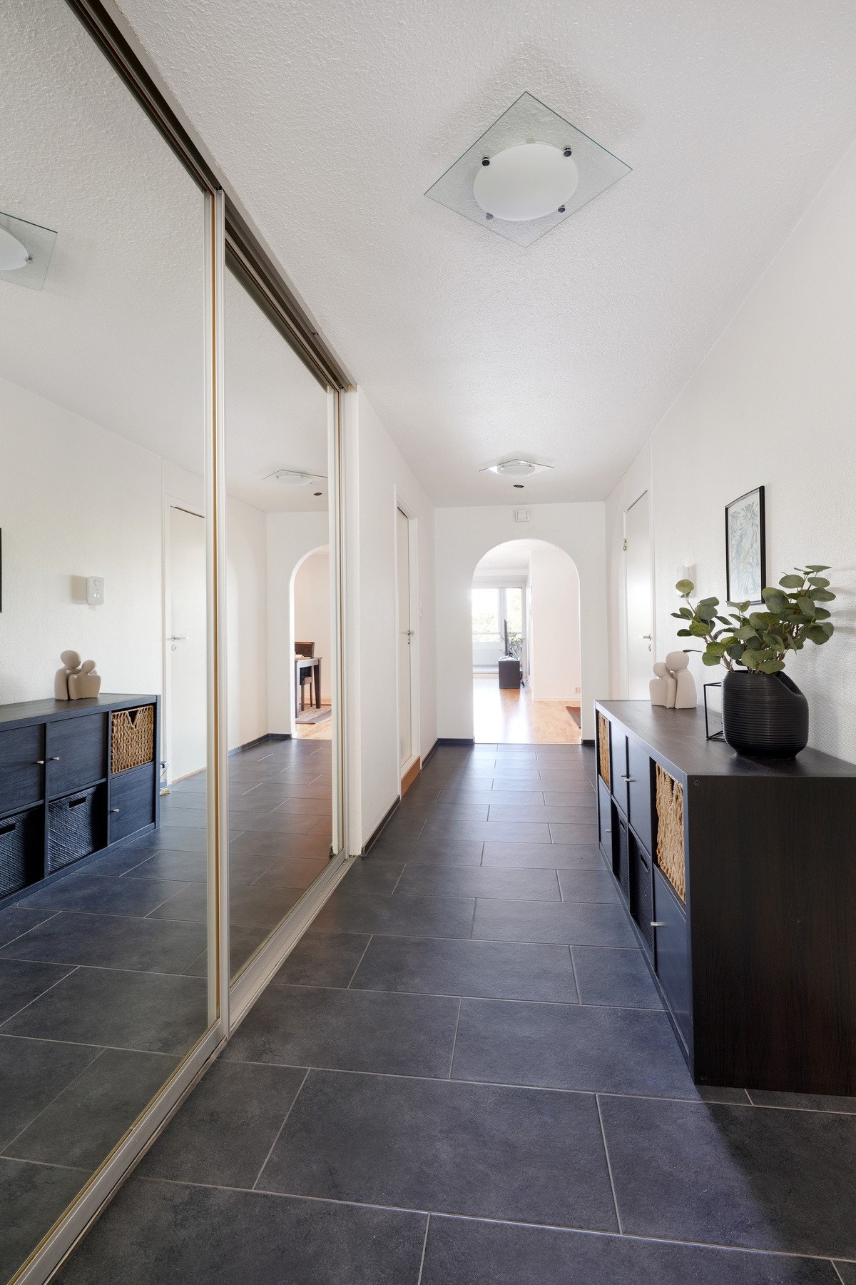 Flisbelagt gang med en stor garderobeskap. Galleribilde