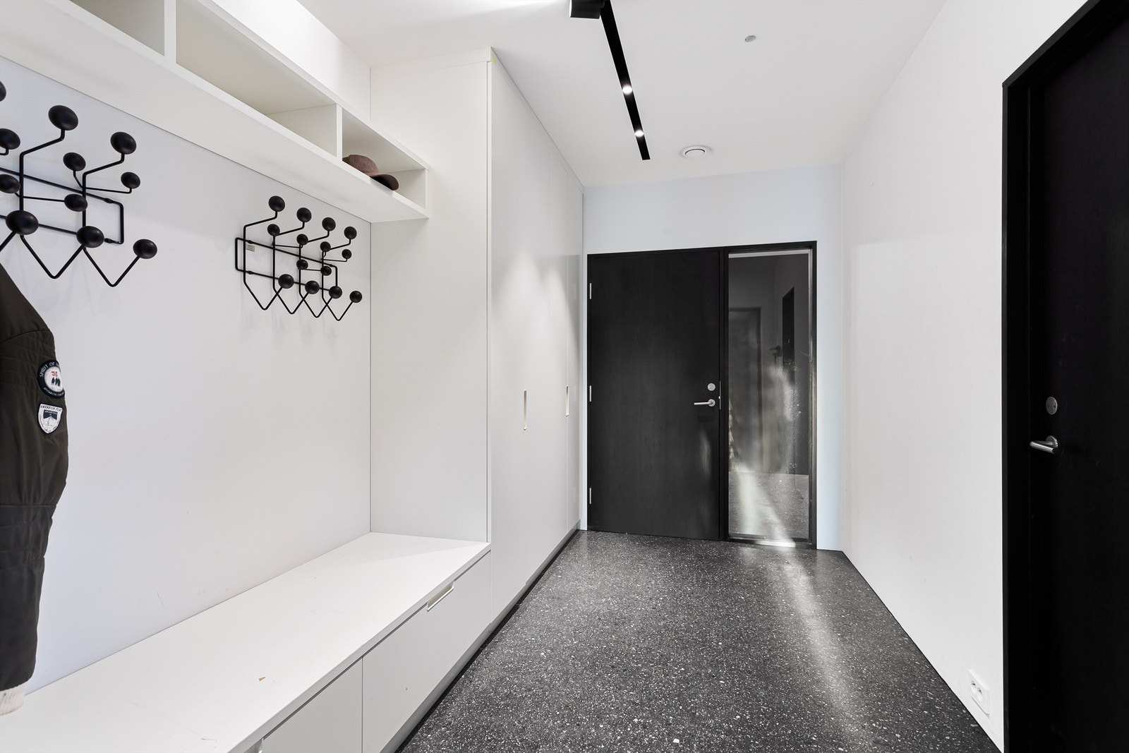 Sluse med garderobeløsning mellom garasjen og boligen Galleribilde