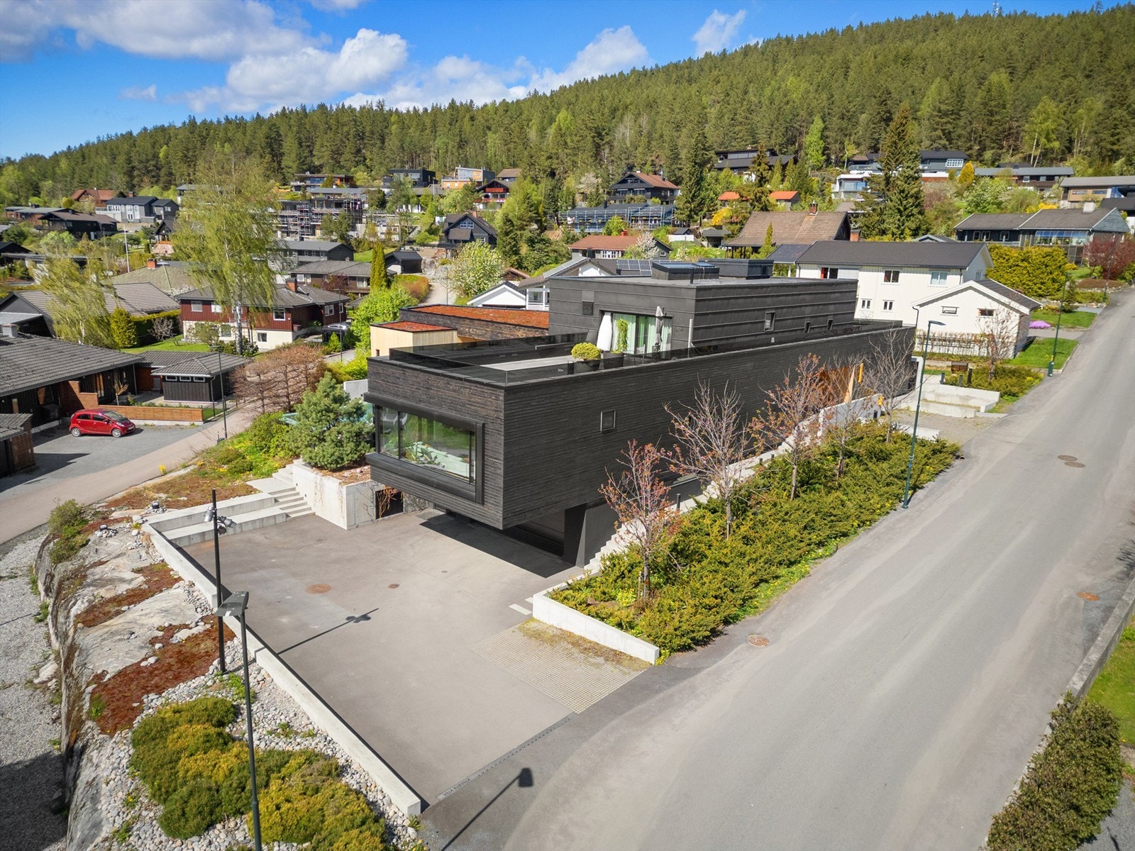 Tomten er pent opparbeidet med diverse beplantninger, noe plen, støttemurer og støpte adkomstveier samt trapper Galleribilde