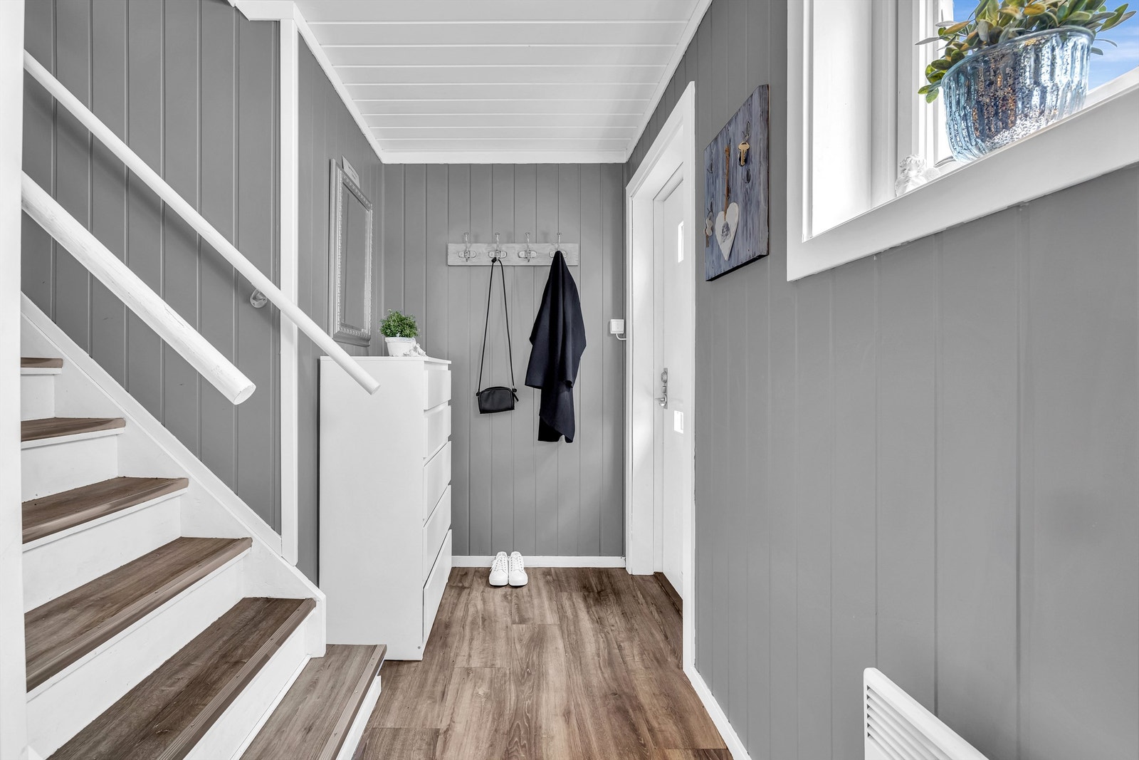 Lys og innbydende entré med plass til å henge fra seg yttertøy og sette fra seg sko. Galleribilde