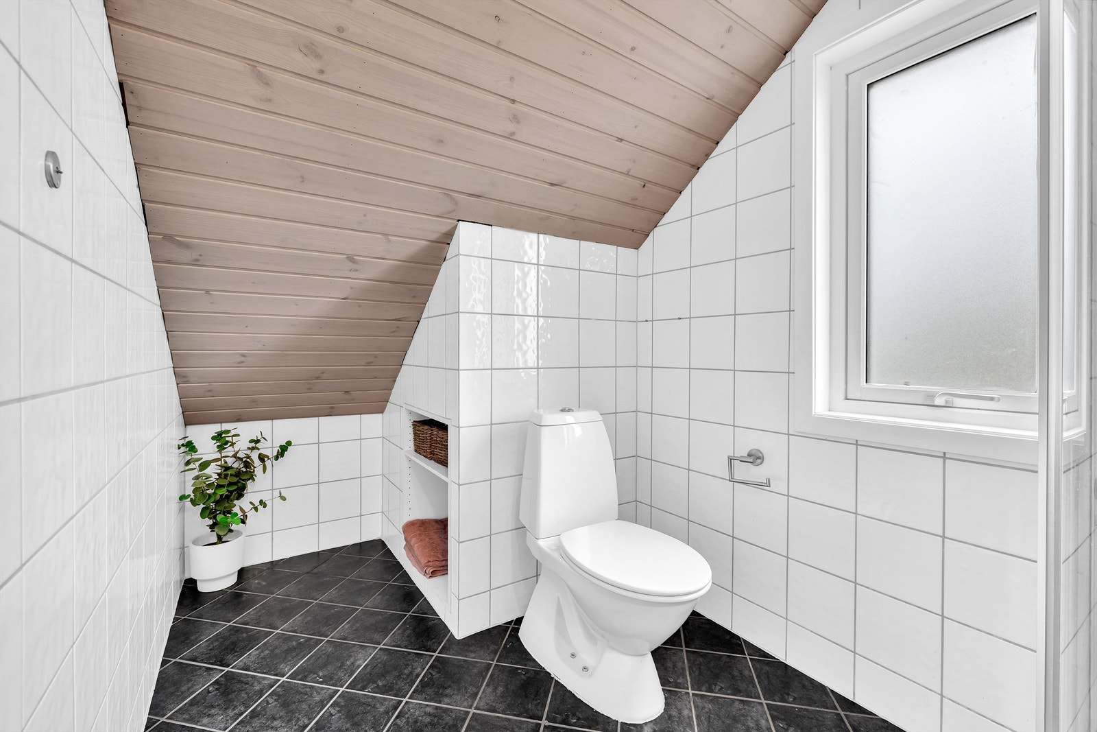 Badet er innredet med nyere dusjkabinett, gulvstående toalett og servantskap med praktiske skuffer. Galleribilde