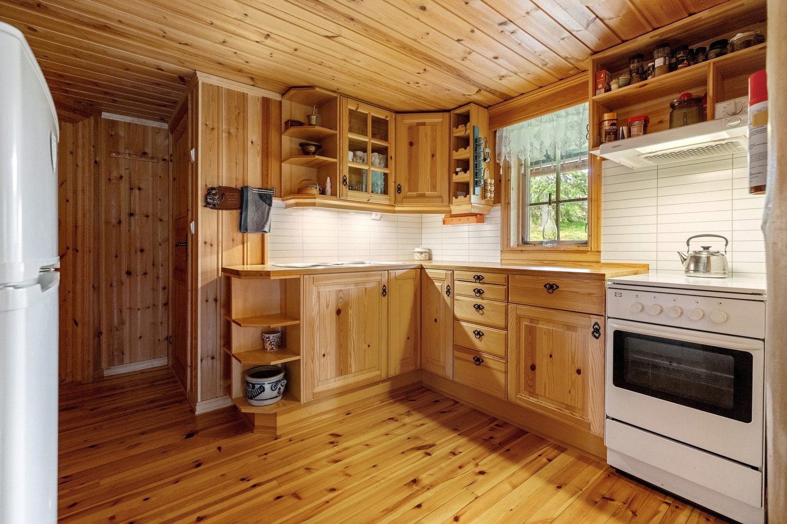 Kjøkkeninnredningen består av furufronter med profiler. Laminerte benkeplater med nedfelt oppvaskkum av metall. Galleribilde