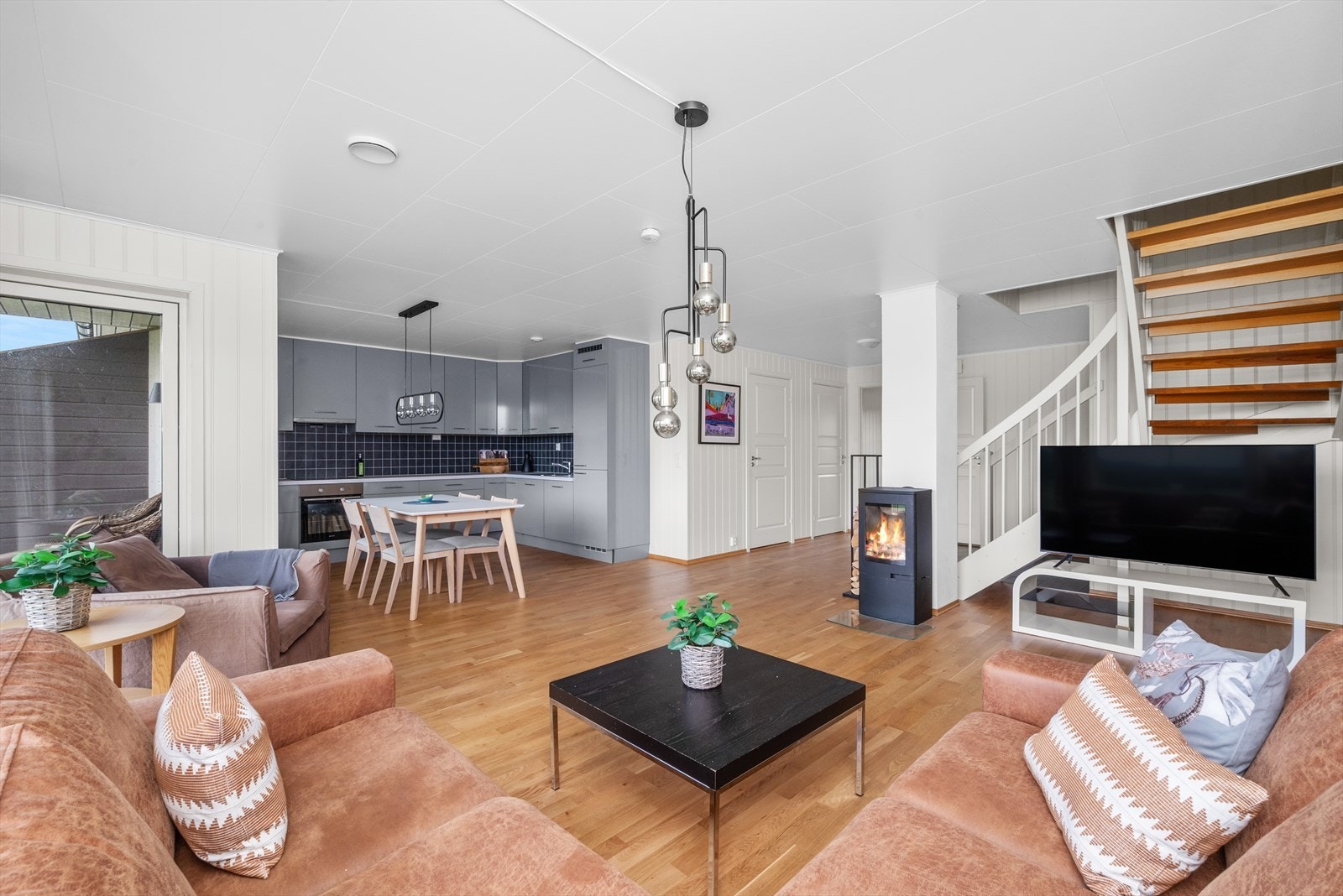 Stor stue/kjøkkendel med rikelig med lysinnslipp fra store vindusflater Galleribilde