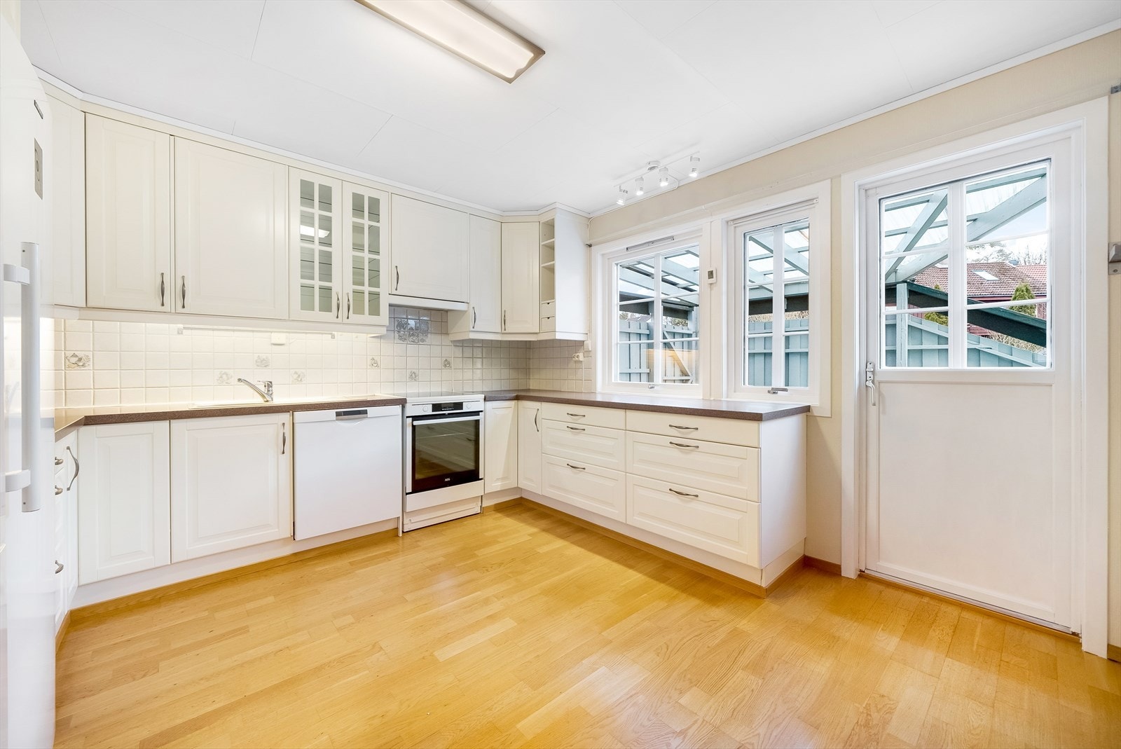 Kjøkken fra Ikea med enkeltstående hvitevarer. Utgang til veranda. Galleribilde