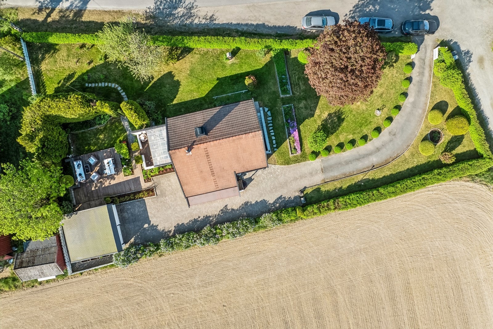 Boligen har en meget pent opparbeidet tomt med plen, prydbusker og innkjørsel med biloppstillingsplasser Galleribilde