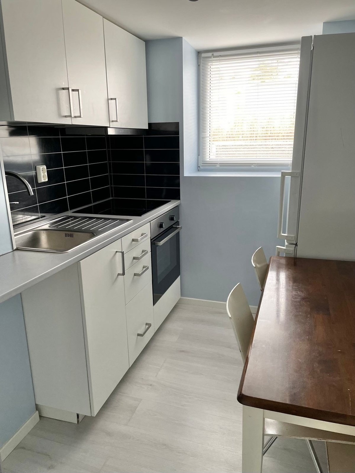 Kjøkkenet i kjelleren har innredning med glatte fronter. Benkeplaten er av laminat med nedfelt kum Galleribilde