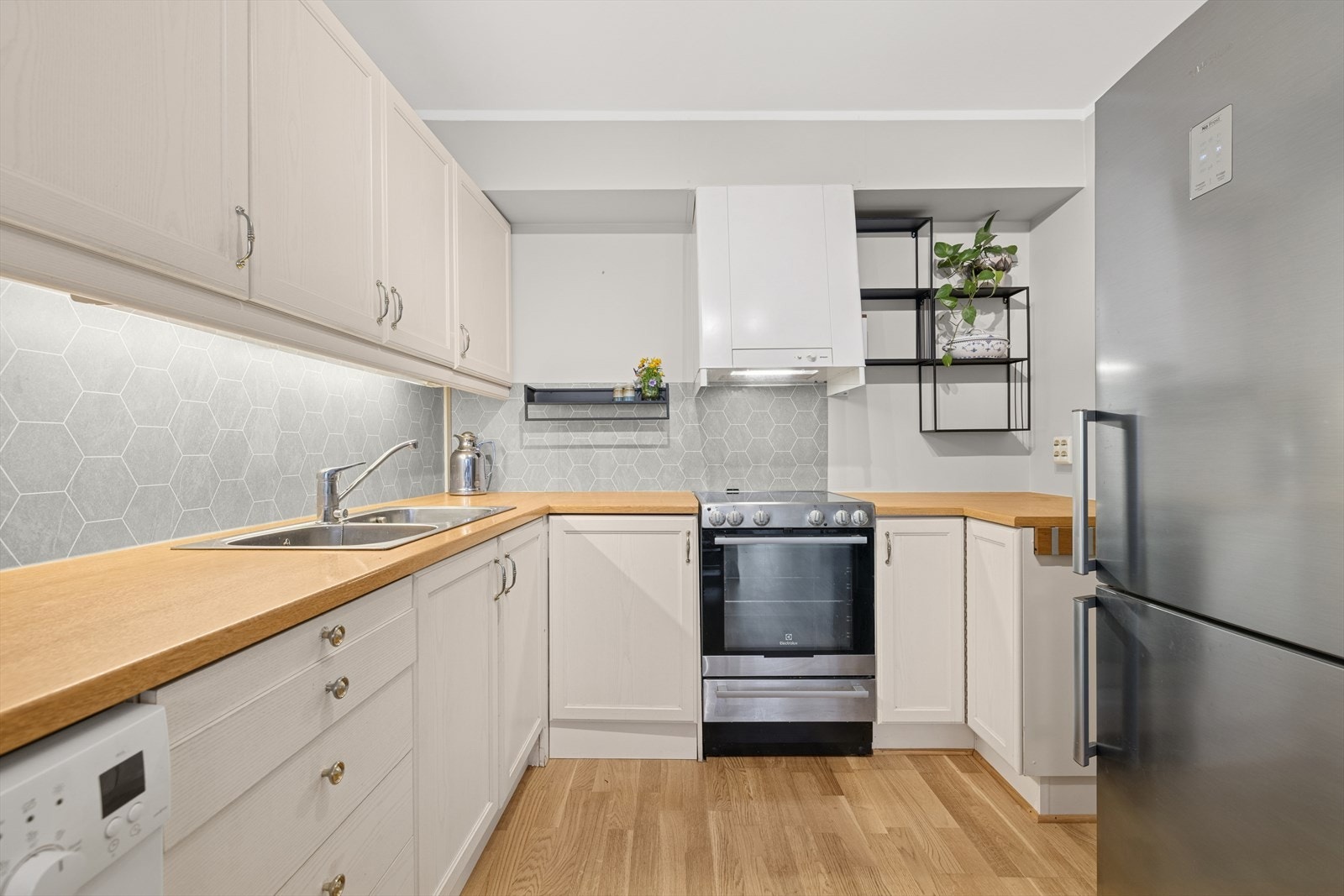 Kjøkkenet har en lys innredning med profilerte fronter og en benkeplate av laminat. Galleribilde