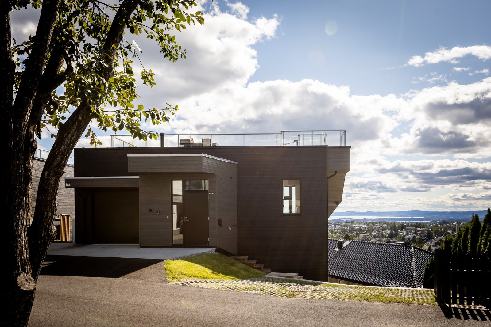 Inngangsparti med innvendig garasje med bilheis og plass til to biler, samt ekstra biloppstillingsplass. Galleribilde