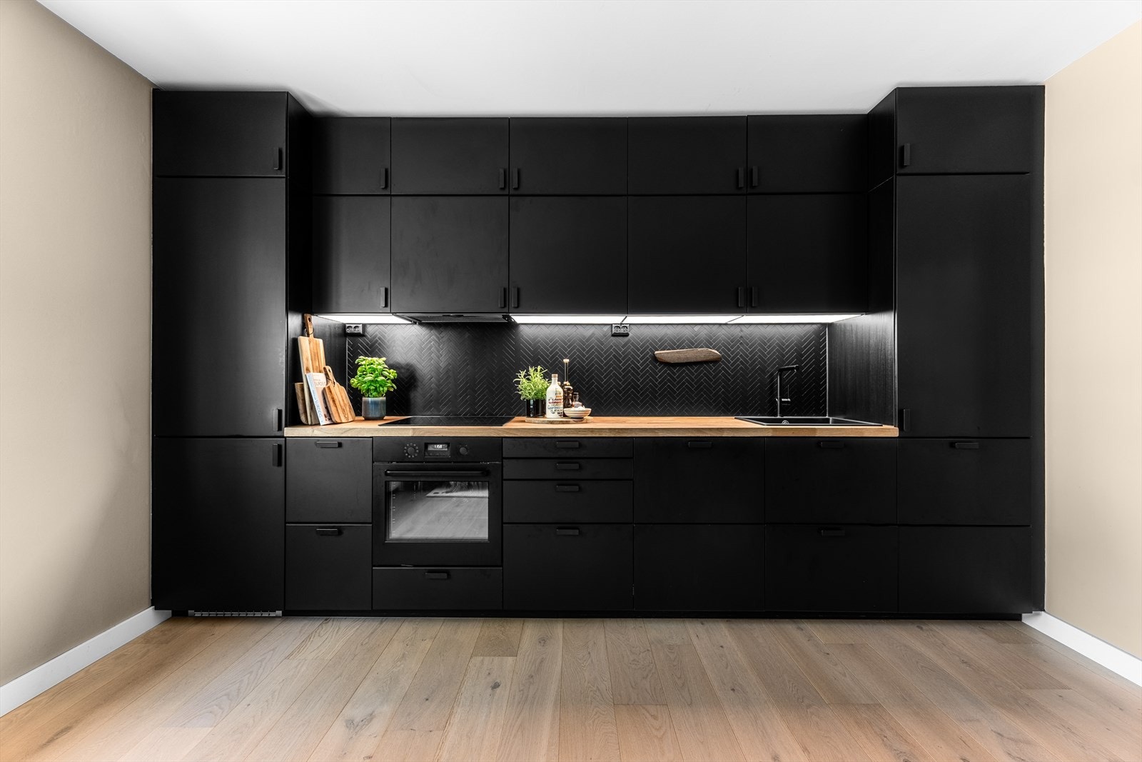 Moderne og velutstyrt kjøkkeninnredning med massevis av skap- og benkeplass. Galleribilde