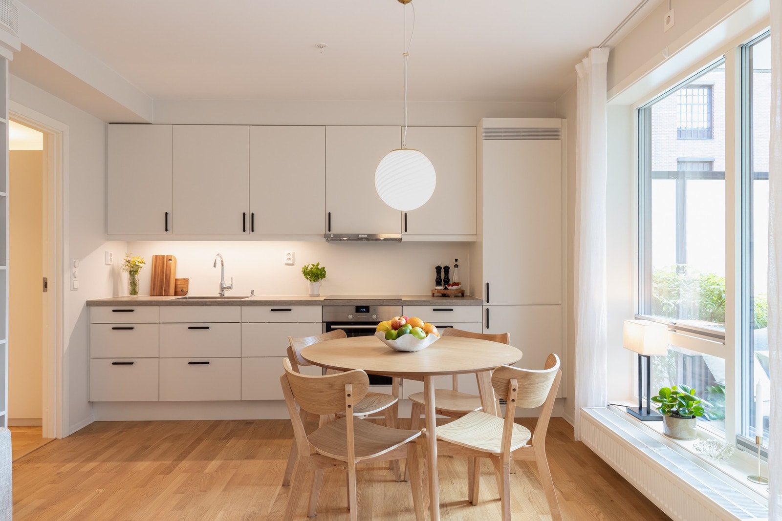 Lys innredning fra Sigdal som har fabrikklakkerte fronter og laminat benkeplate med nedfelt oppvaskkum og nedfelt induksjon koketopp. Galleribilde