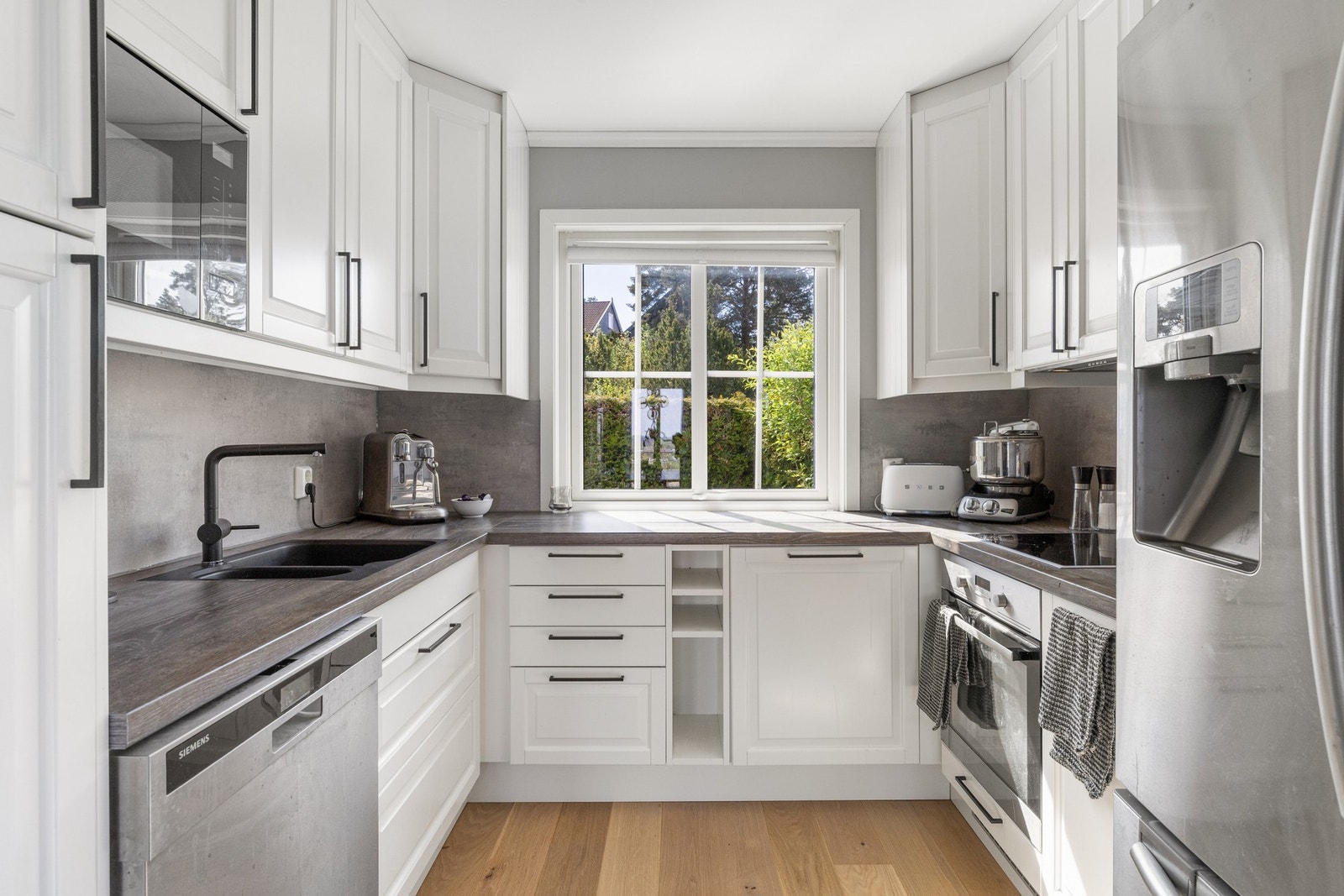 Kjøkkenet har profilerte fronter, laminat benkeplate og integrerte hvitevarer Galleribilde