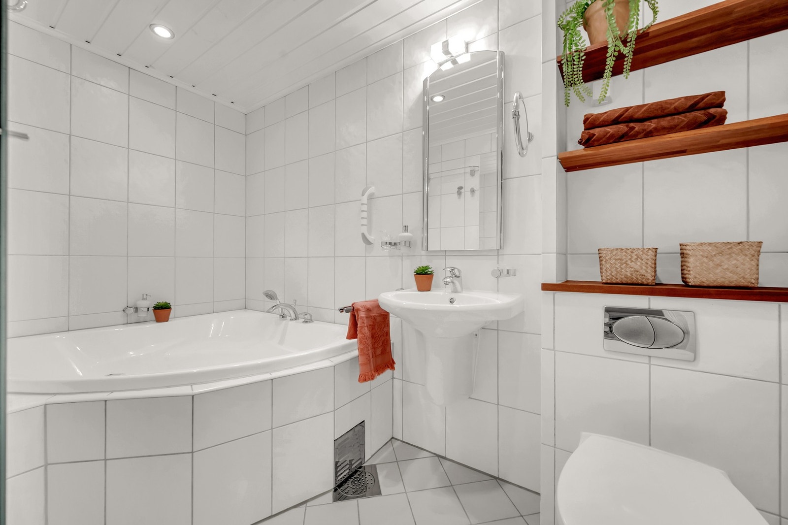 Leiligheten har et tidløst, flislagt bad fra 2000 med behagelig gulvvarme, badekar og himling med downlights. Galleribilde