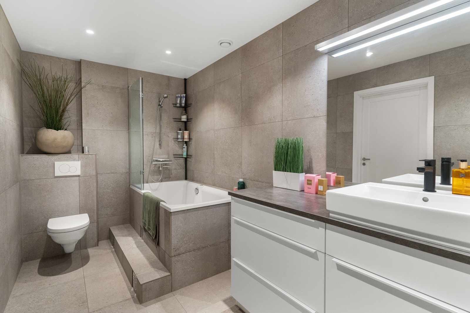 Bad og vaskerom med stort og dypt ståbadekar, hvor det også er hånddusj. Galleribilde