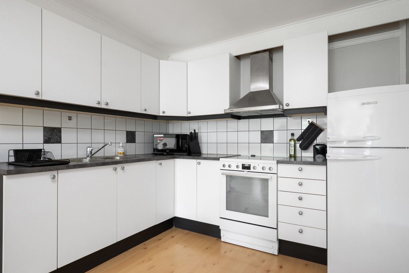 Stuen og kjøkkenet danner et åpent og romslig allrom, og kjøkkeninnredningen har glatte fronter, laminatbenkeplate og ventilator. Galleribilde