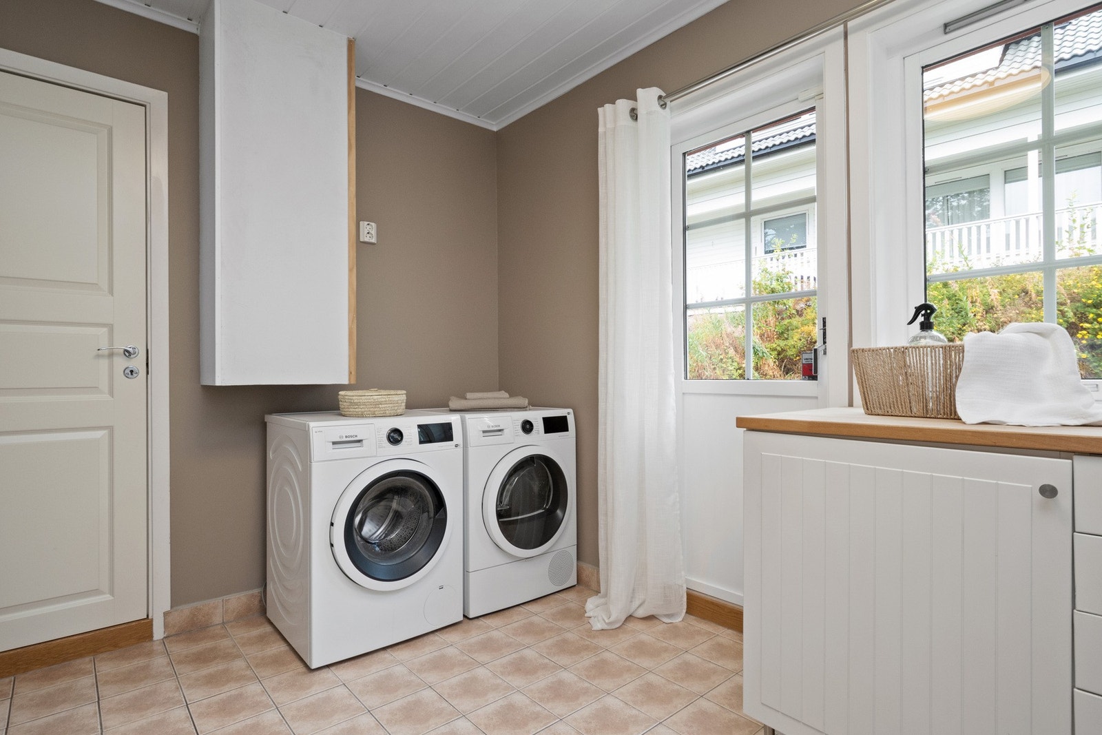 Vaskerommet har egen utgang til hagen, og rommet har malte vegger og fliser på gulv med gulvvarme. Galleribilde