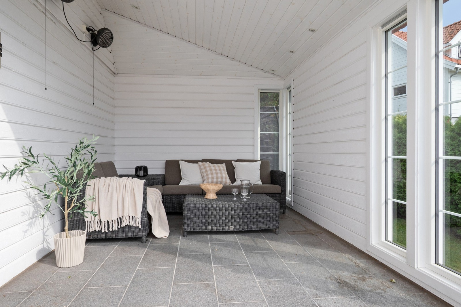 Terrassen har dekke med terrassebord og fliser, og på husveggen er det montert både utestikk og stemningsfull utebelysning. Galleribilde