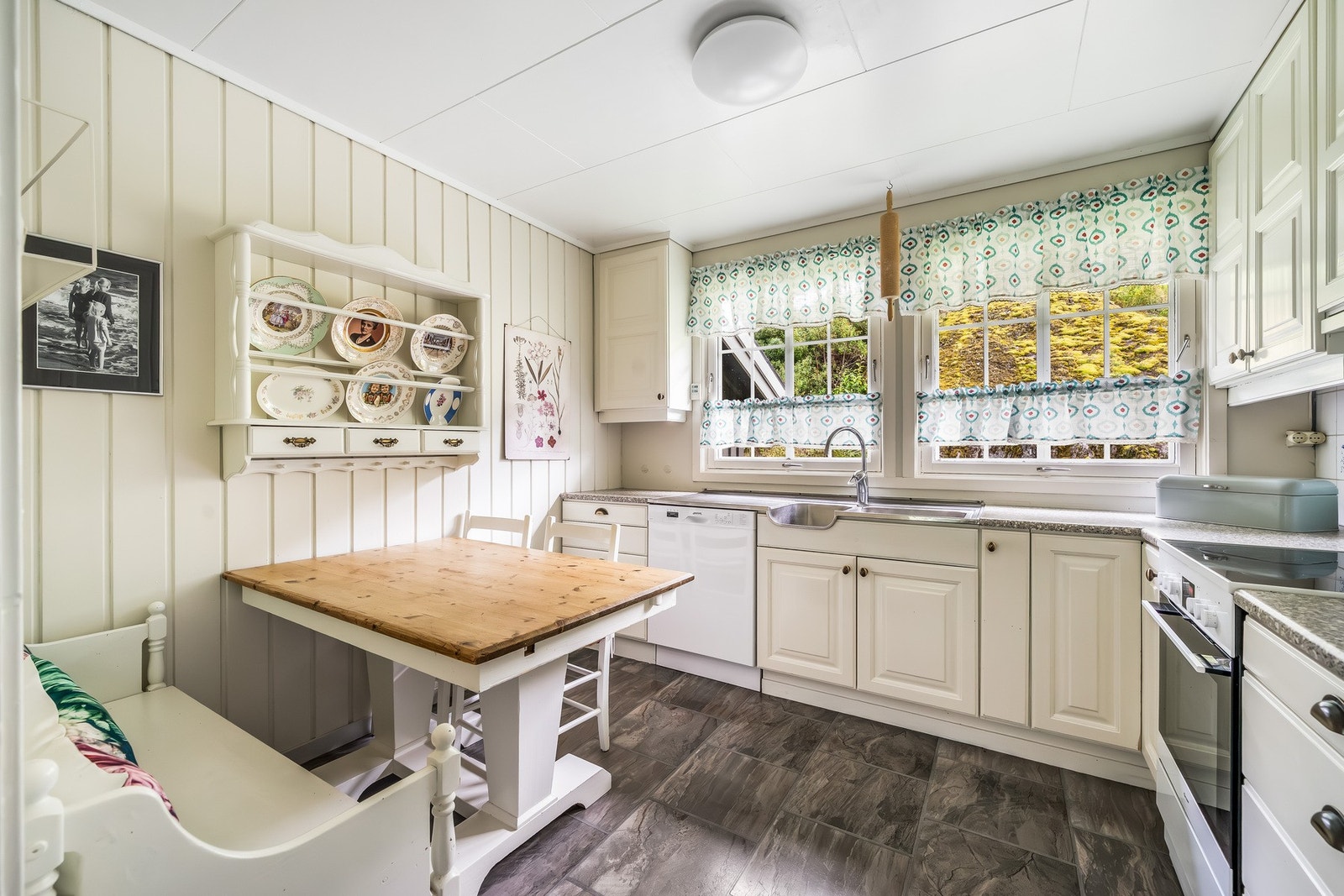 Lyst og innbydende kjøkken med god skapplass og naturlig lys fra vinduene. Rommet har plass til kjøkkenbord, perfekt til både hverdag og hyggelige måltider. Galleribilde