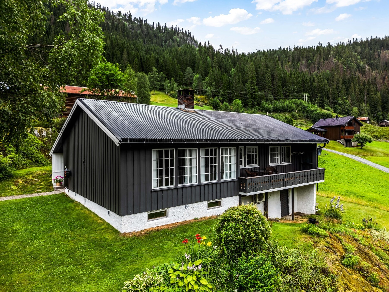 Her kan du nyte en stor og solrik hage med vakker utsikt og frodig beplantning som gir en harmonisk atmosfære. Hagen byr på rikelig med boltreplass for både store og små, og innbyr til lek, sosiale sammenkomster eller rolige stunder i grønne omgivelser. Galleribilde