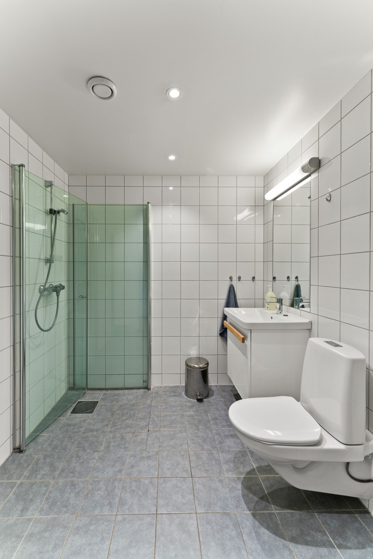 Rommet har innredning med nedfelt servant, veggmontert toalett, dusjhjørne og opplegg for vaskemaskin. Galleribilde