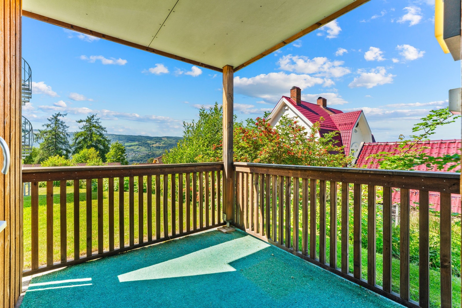 Fra stuen er det utgang til en overbygd balkong på ca. 5 kvm, som fungerer som en naturlig forlengelse av stuen om sommeren, med plass til utemøblement og utsyn mot grønne omgivelser. Galleribilde