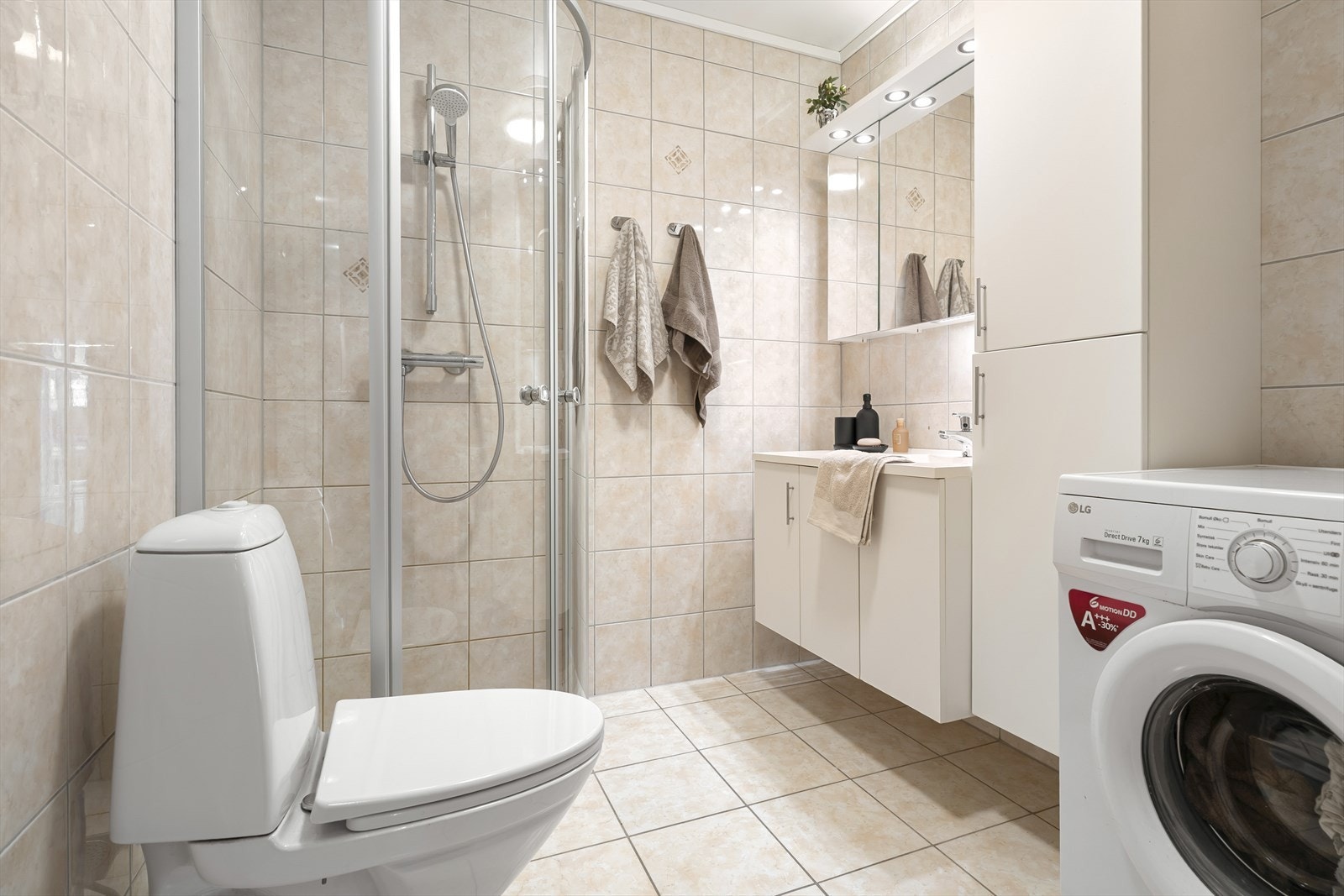 - Badet er helfliset i beige toner og har opplegg til vaskemaskin og tørketrommel - Galleribilde