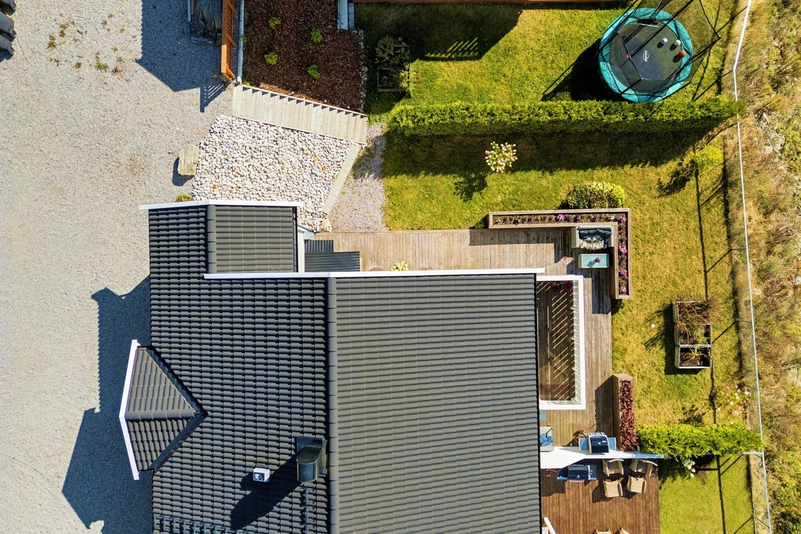 Fra oven ser man hvordan hagen, terrassen og de lune uteområdene danner en perfekt ramme for både lek og avslapning. Galleribilde