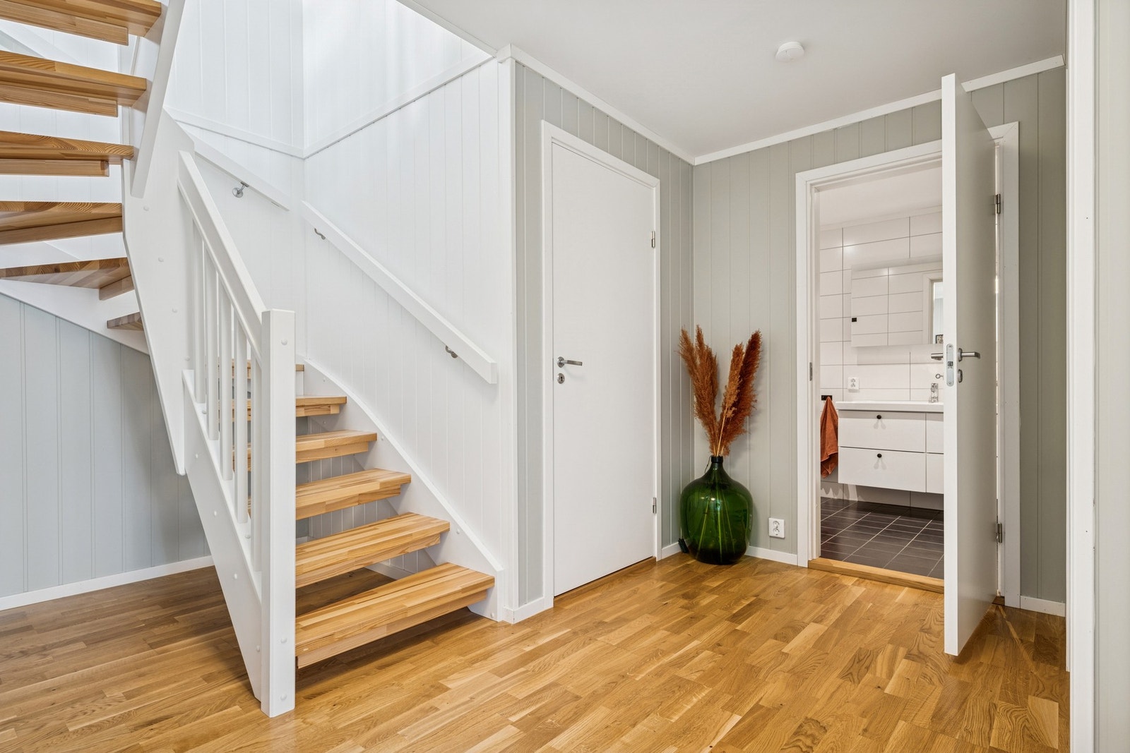 Romslig gang med god plass til oppbevaring og en praktisk planløsning som binder etasjen sammen. Galleribilde