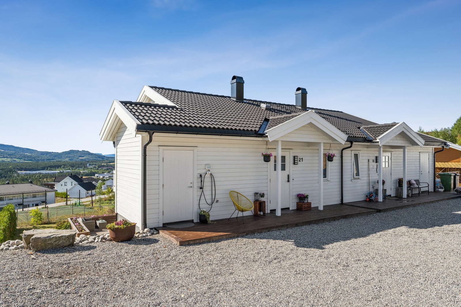 Parkeringsplasser rett utenfor døren og elbil lader montert på veggen. Galleribilde