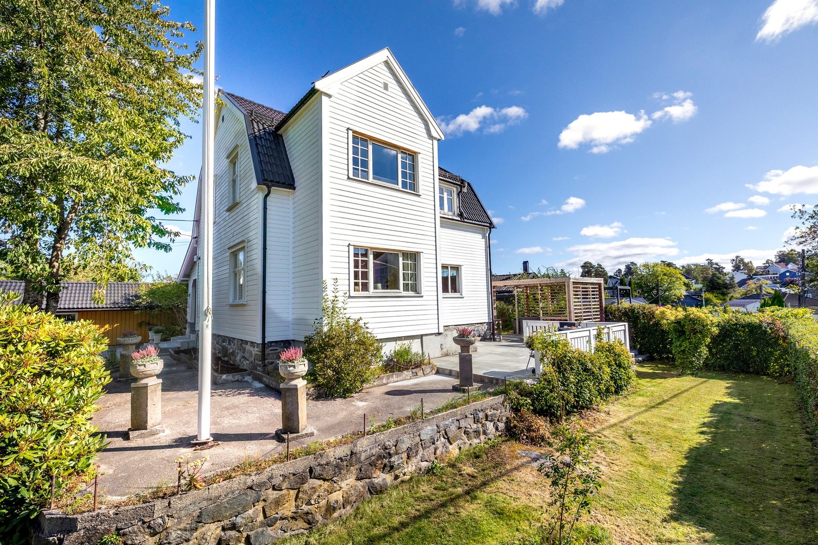 Eiendommen er også utstyrt med flaggstang, som tilfører en klassisk og tradisjonell ramme til hagen. Galleribilde