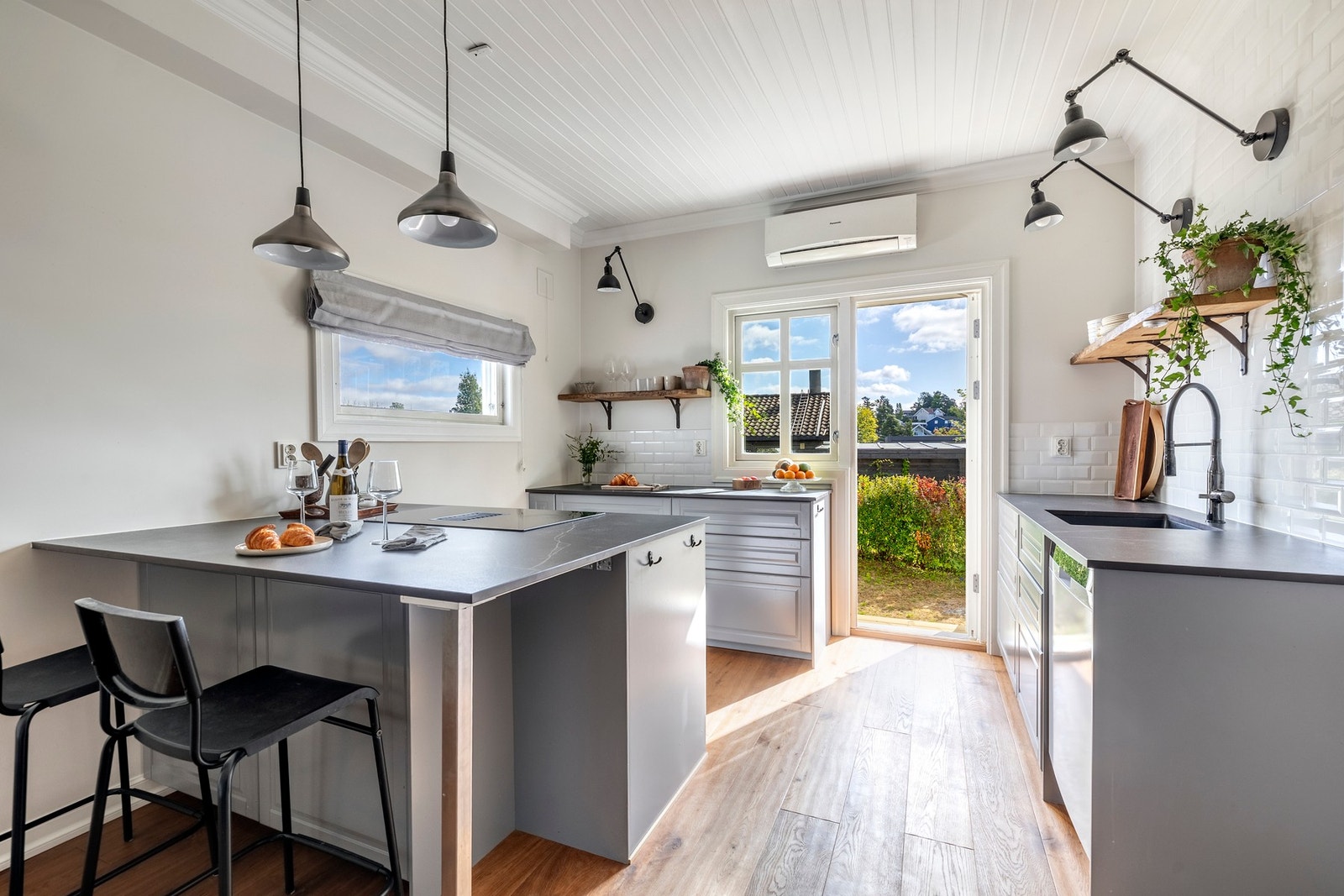 Kjøkkenet har grå profilerte fronter og benkeplater av høytrykkporselen med nedfelt oppvaskkum i kompositt. Galleribilde