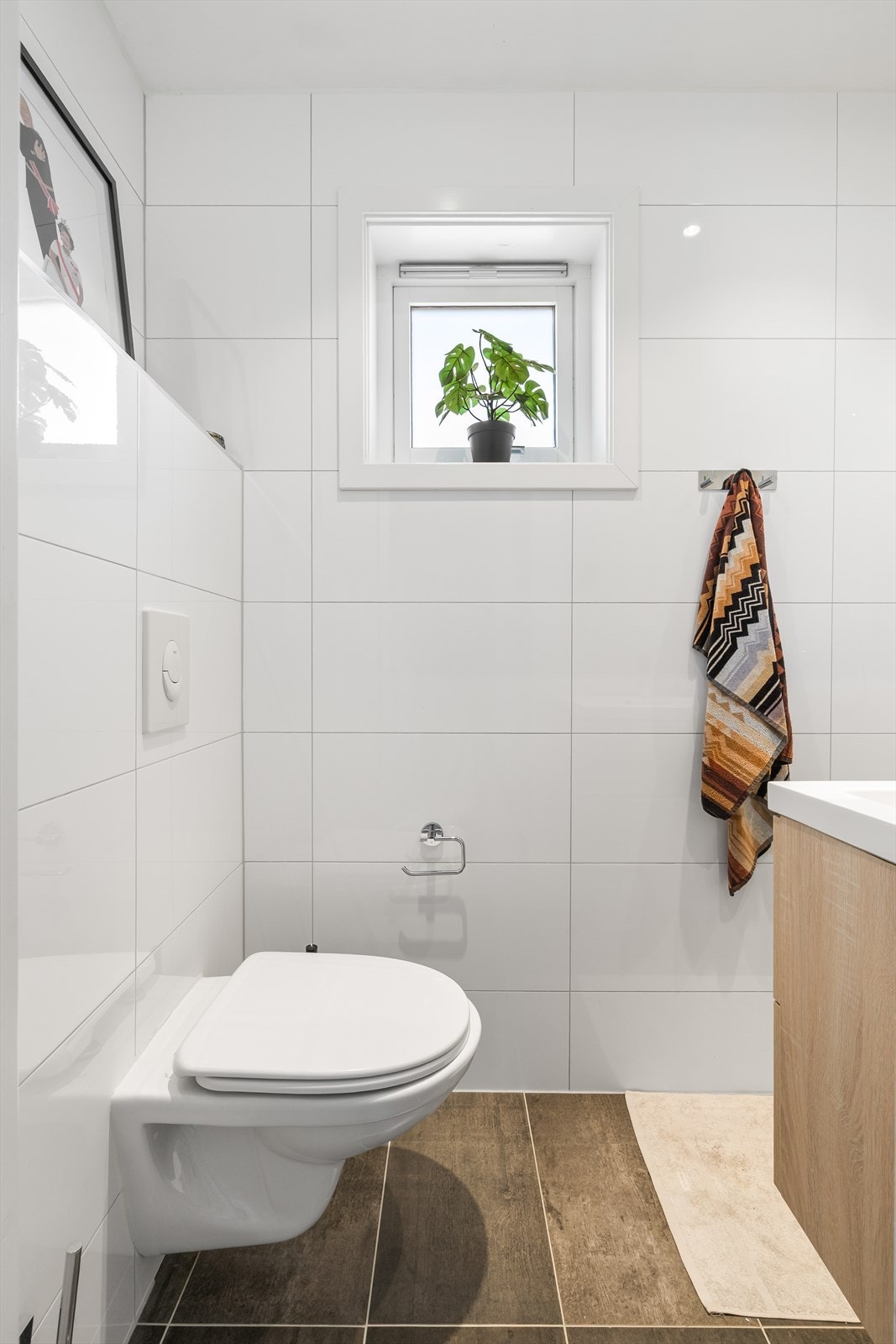 Badet er stilrent med fliser på vegg og gulv Galleribilde