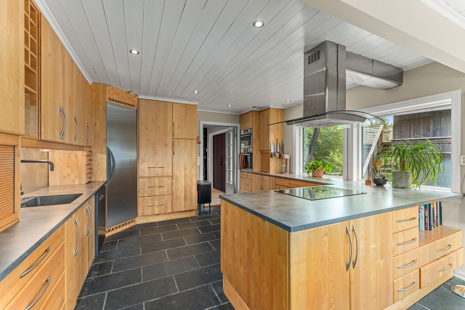 Kjøkkenet er både funksjonelt og stilrent, med god skap- og benkeplass. Innredningen er utført i heltre med en varm og tidløs utførelse som gir en solid og klassisk følelse. Galleribilde