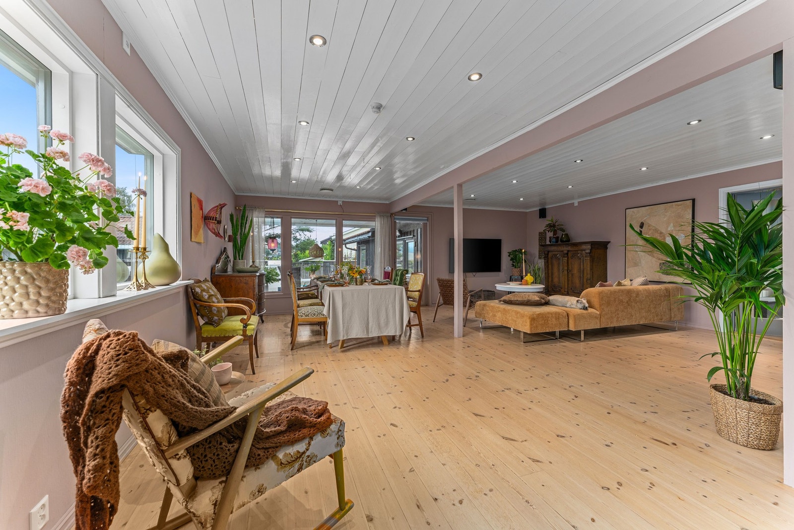 Stuen har store vindusflater som gir rikelig med naturlig lys, og en peis som skaper en lun atmosfære. Rommet har plass til flere møbelsoner og oppleves både sosialt og åpent. Galleribilde