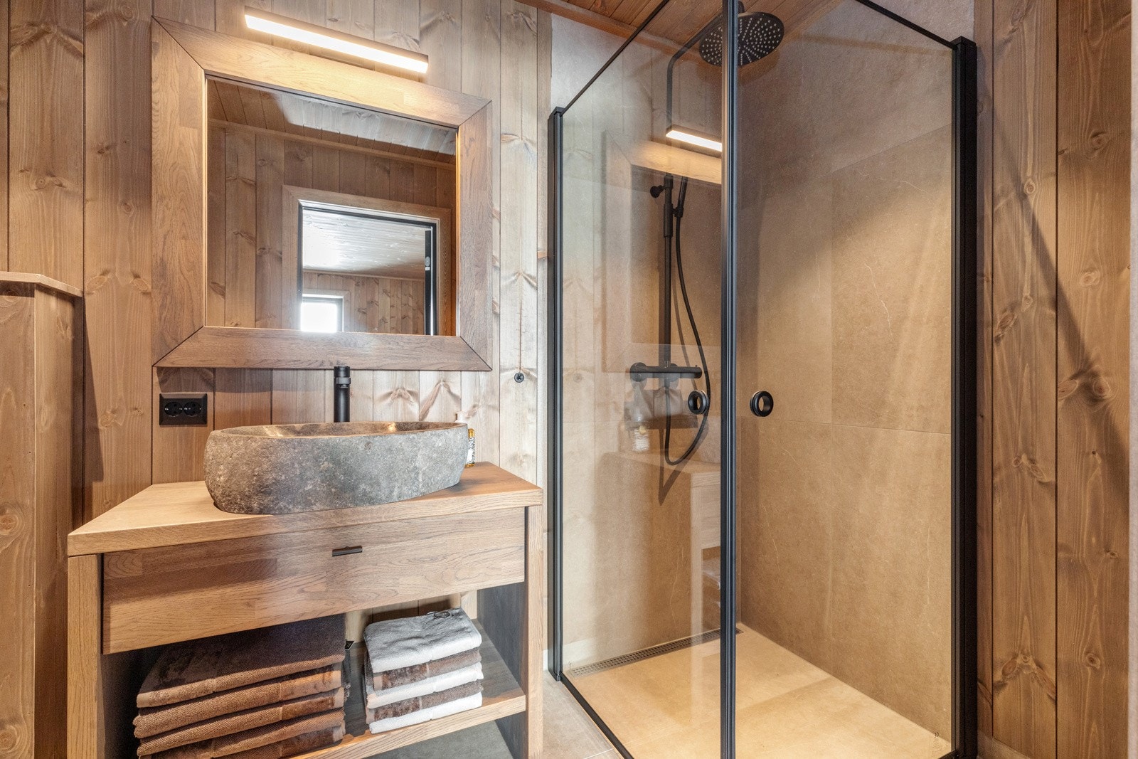 To stilrene bad med beiset panel på vegger og fliser på gulv Galleribilde