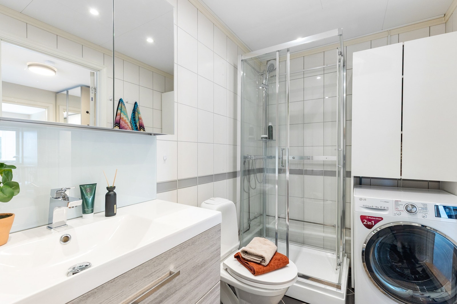 Det er både plass og opplegg for vaskemaskin i tilpasset innredning med overskap. Galleribilde