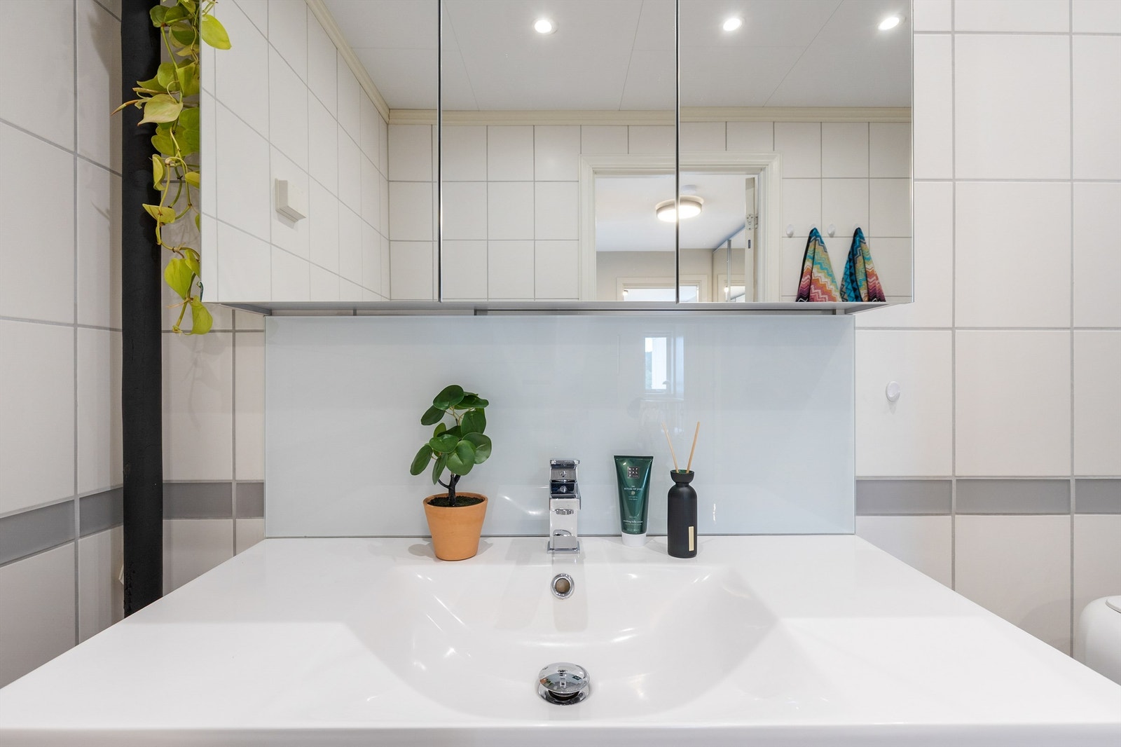 Badet er innredet med toalett, servant nedfelt i innredning, speilskap og dusjkabinett. Galleribilde