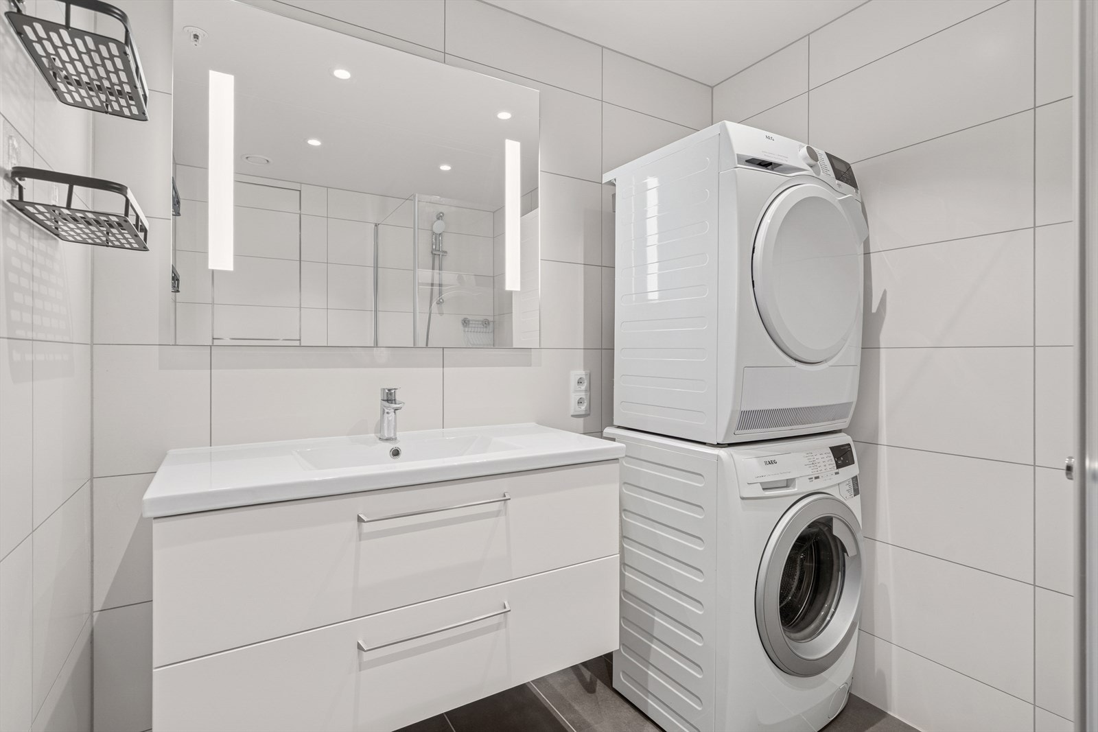 Badet er godt utnyttet med hvite fliser på veggene og grå på gulvet. Det er lagt varmekabler i gulvet Galleribilde