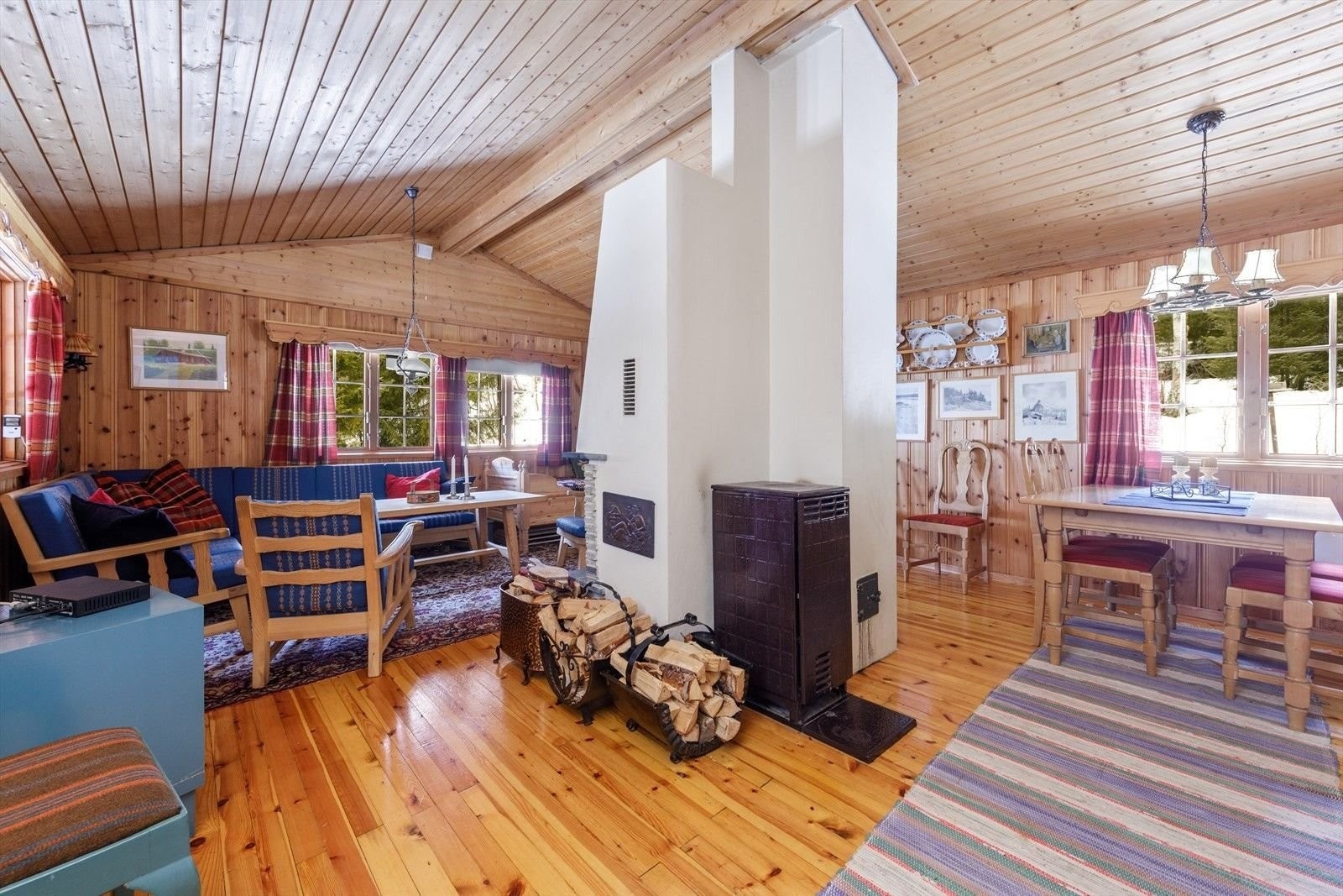 Romslig stue med god plass til spisebord. Det er satt inn ny vedovn på nyåret 2024: https://www.seljordvarme.no/ovner/vedovner/regin-kompakt/c-49/c-434/p-16278/
Den er liten, men supereffektiv for å få opp varmen. Galleribilde