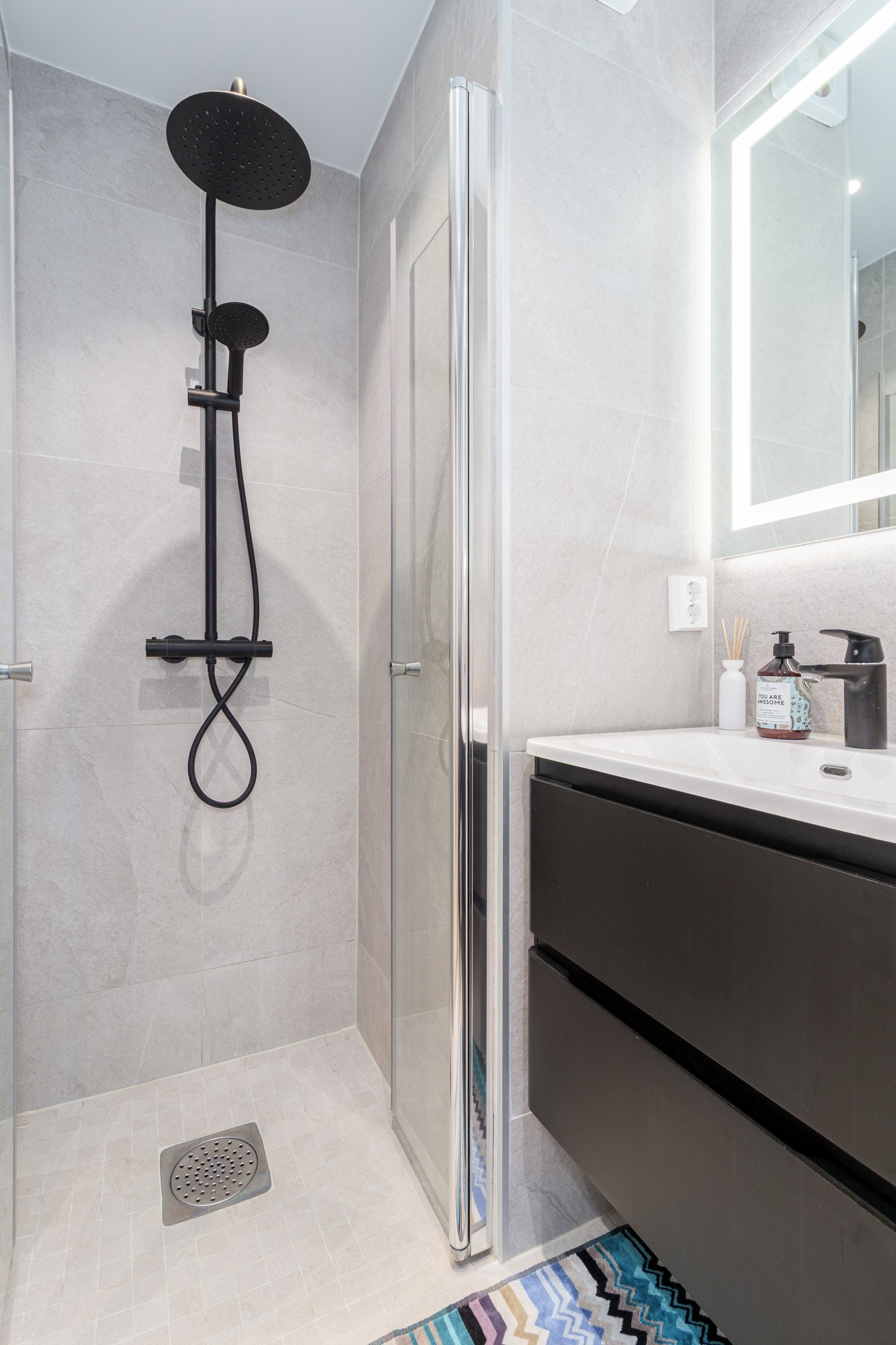 Detaljer i svart gir badet et eksklusivt preg. Badet er utstyrt med toalett, dusj med innfellbare dører, benkeskap og speil med belysning, og har en gjennomført, moderne standard. Galleribilde